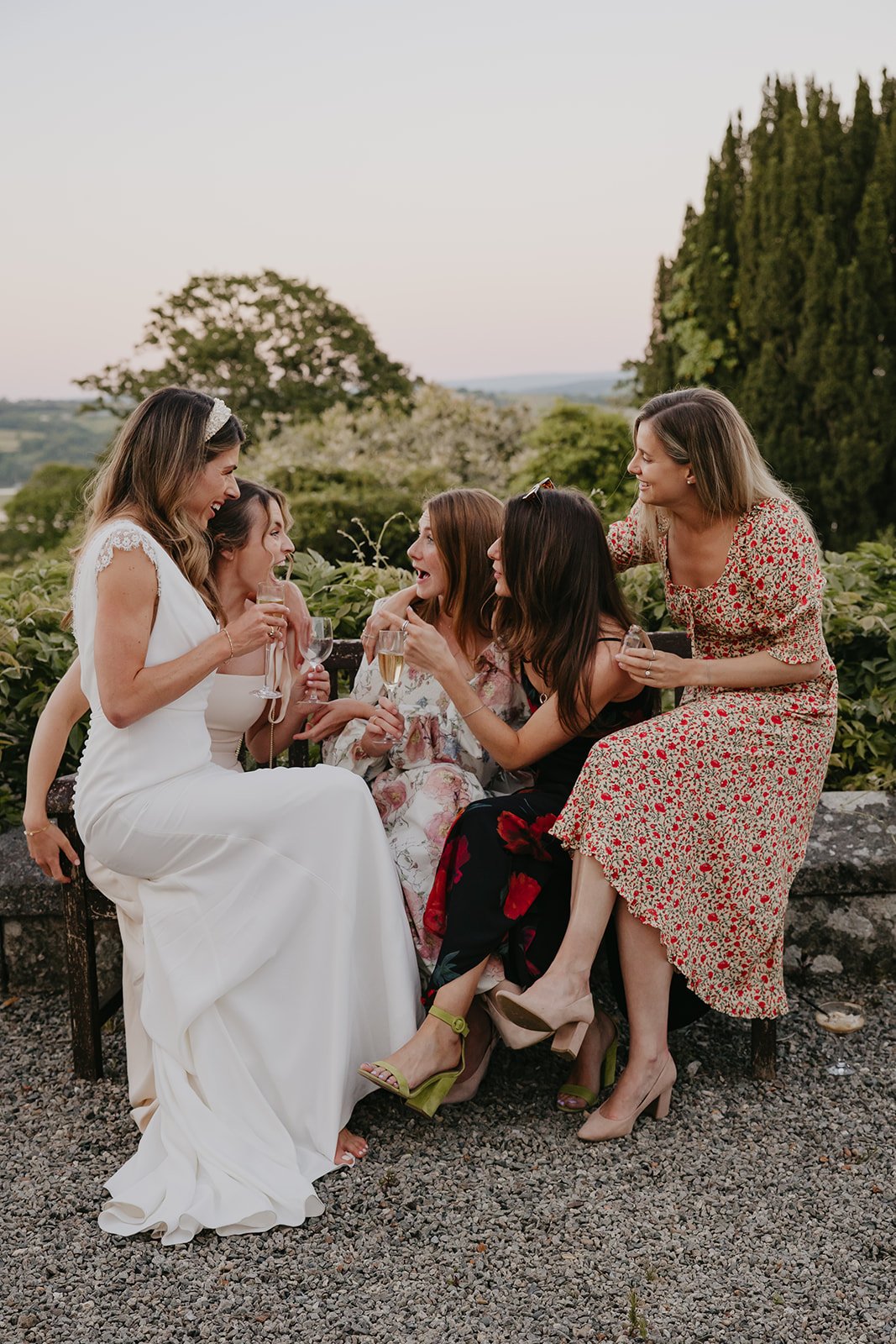 Bride seated on the terraces with friends. Photographed by Hello Pictures.
