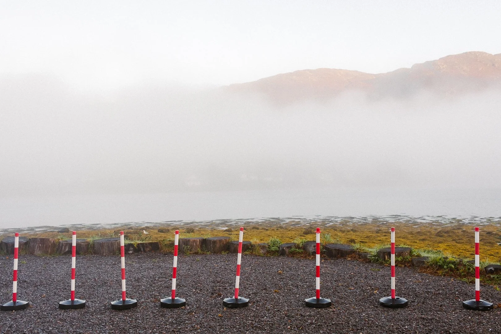 Fogg above the lake surrounded by mountains.