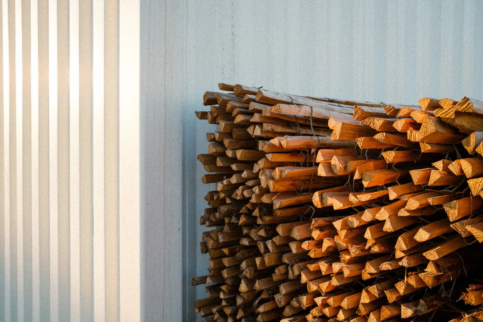 Stack of wooden planks leaning against a wall.