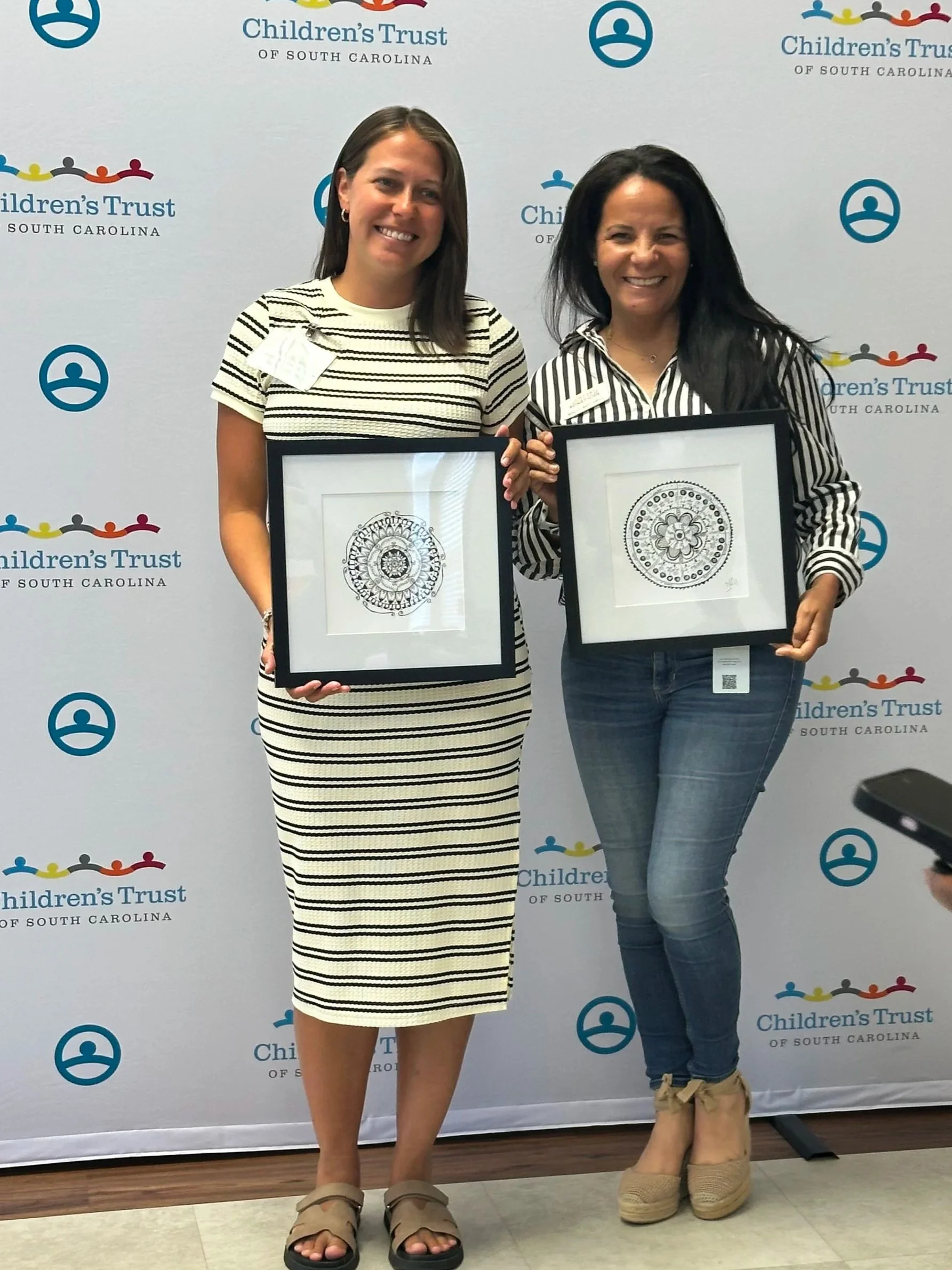 Smiling participants showing finished mandalas at a Sumac Arts resilience training for Children's Trust South Carolina