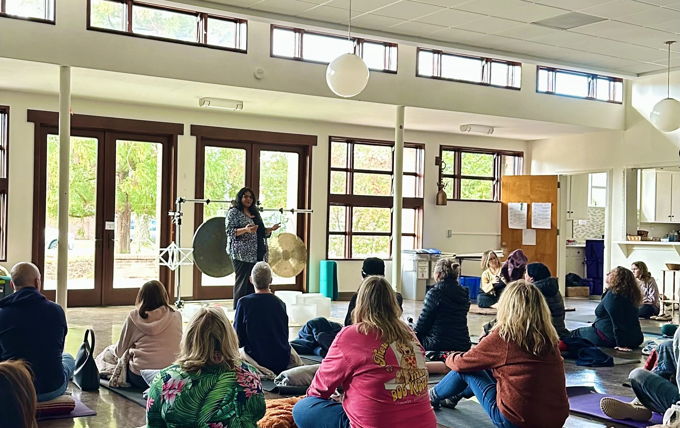 Sudha McFadden speaking in front of a large seated group at a mindfulness session in South Carolina