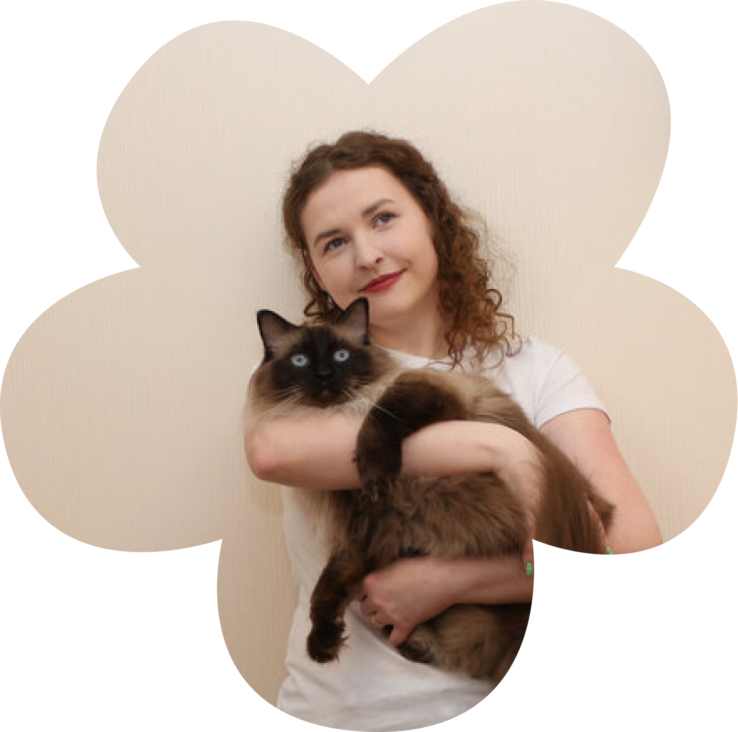 Paula holding her cat, smiling and looking thoughtful.