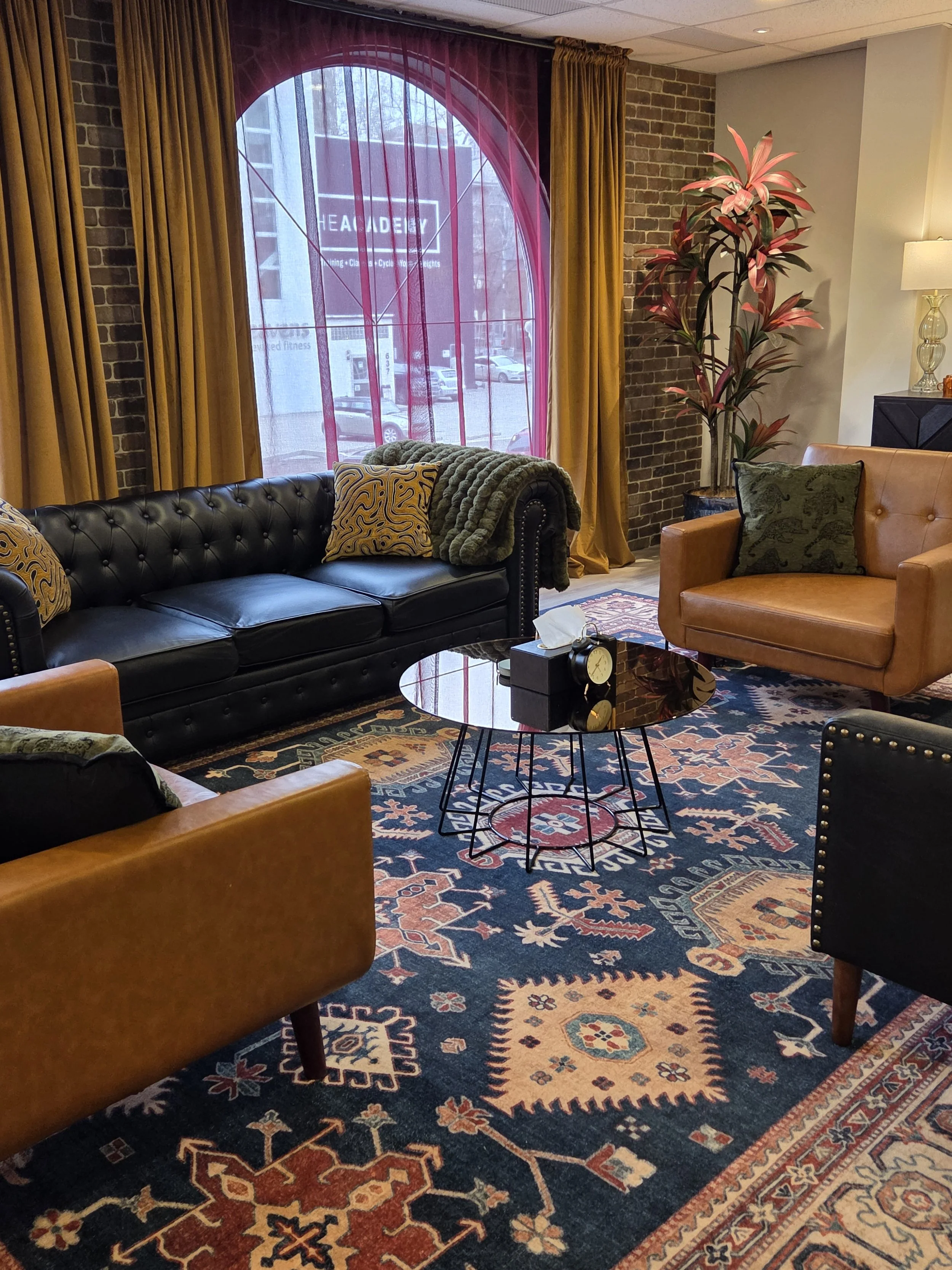 Warm and inviting therapy office in Calgary with faux leather seating and cozy decor for trauma and anxiety counselling