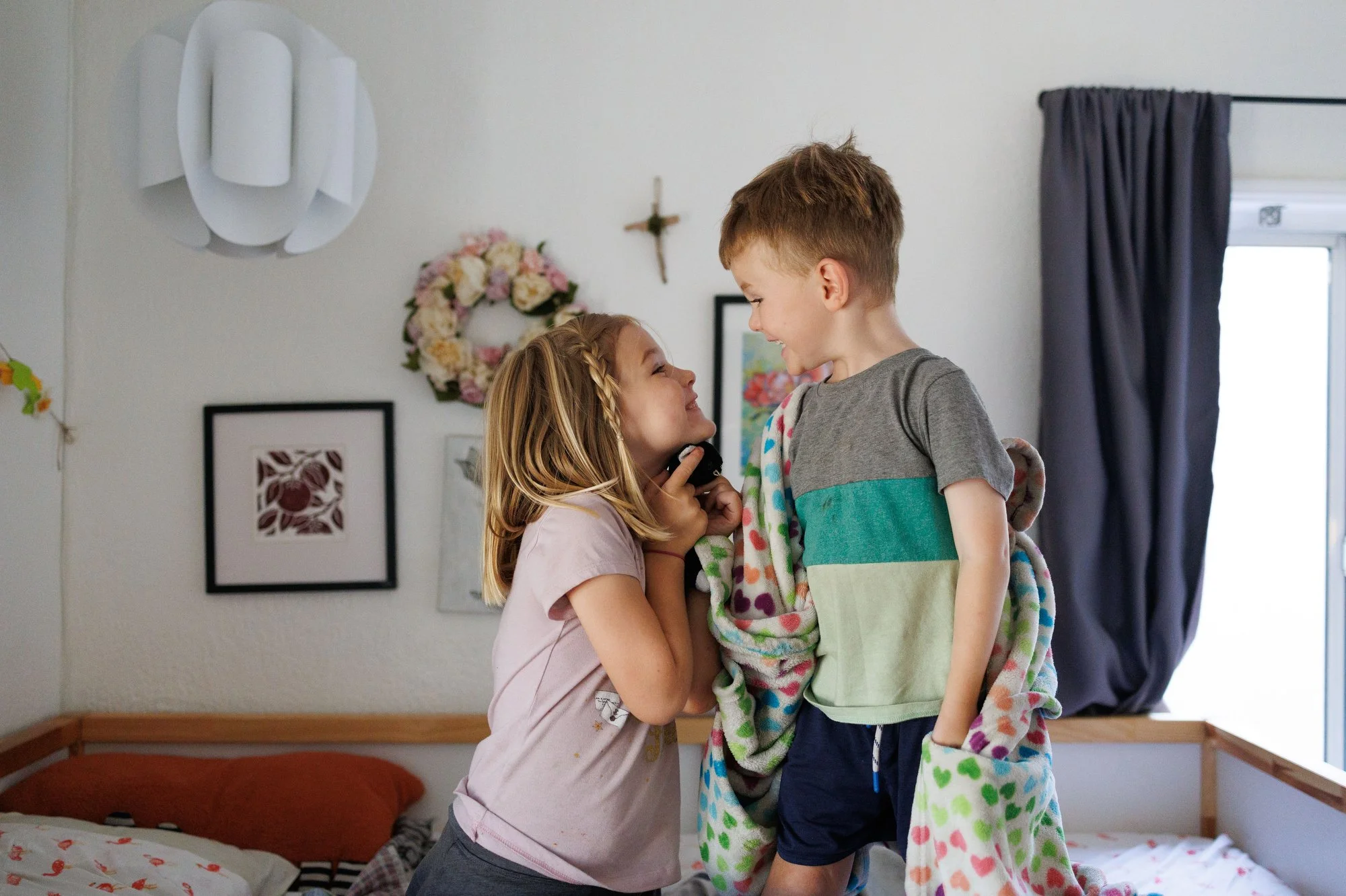 A little girl and boy smile eagerly at each other