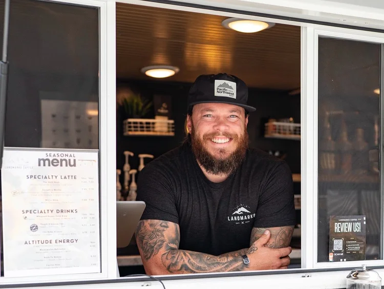 Smiling barista at the Landmarks Coffee trailer window