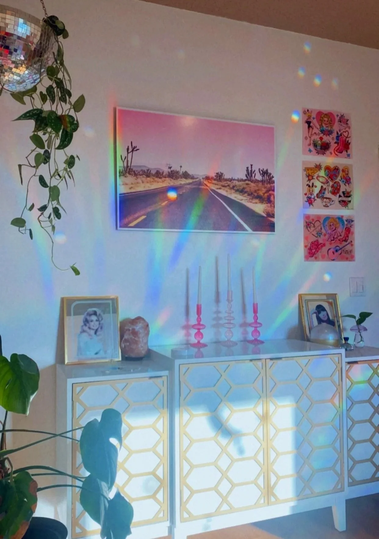 Inside of Luna Beauty and Wellness. Plants, pink art, candles and mirrored images of Cher and Dolly Parton.