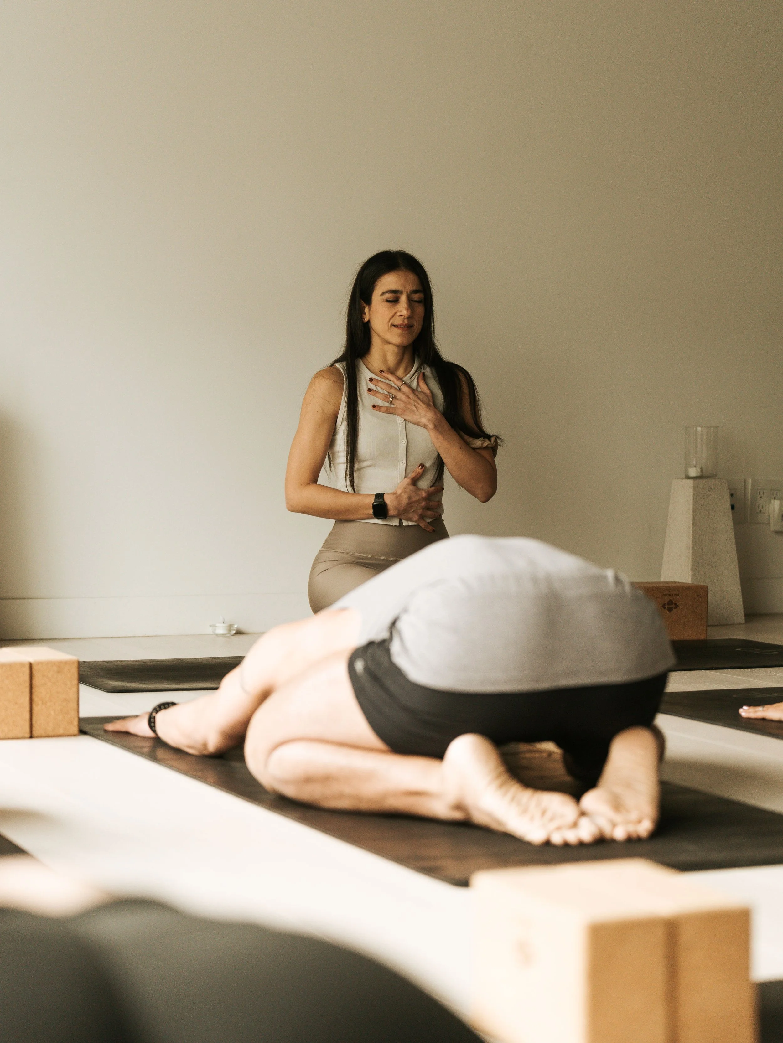 Calm deep stretch yoga class with participants holding long restorative poses in a serene studio setting