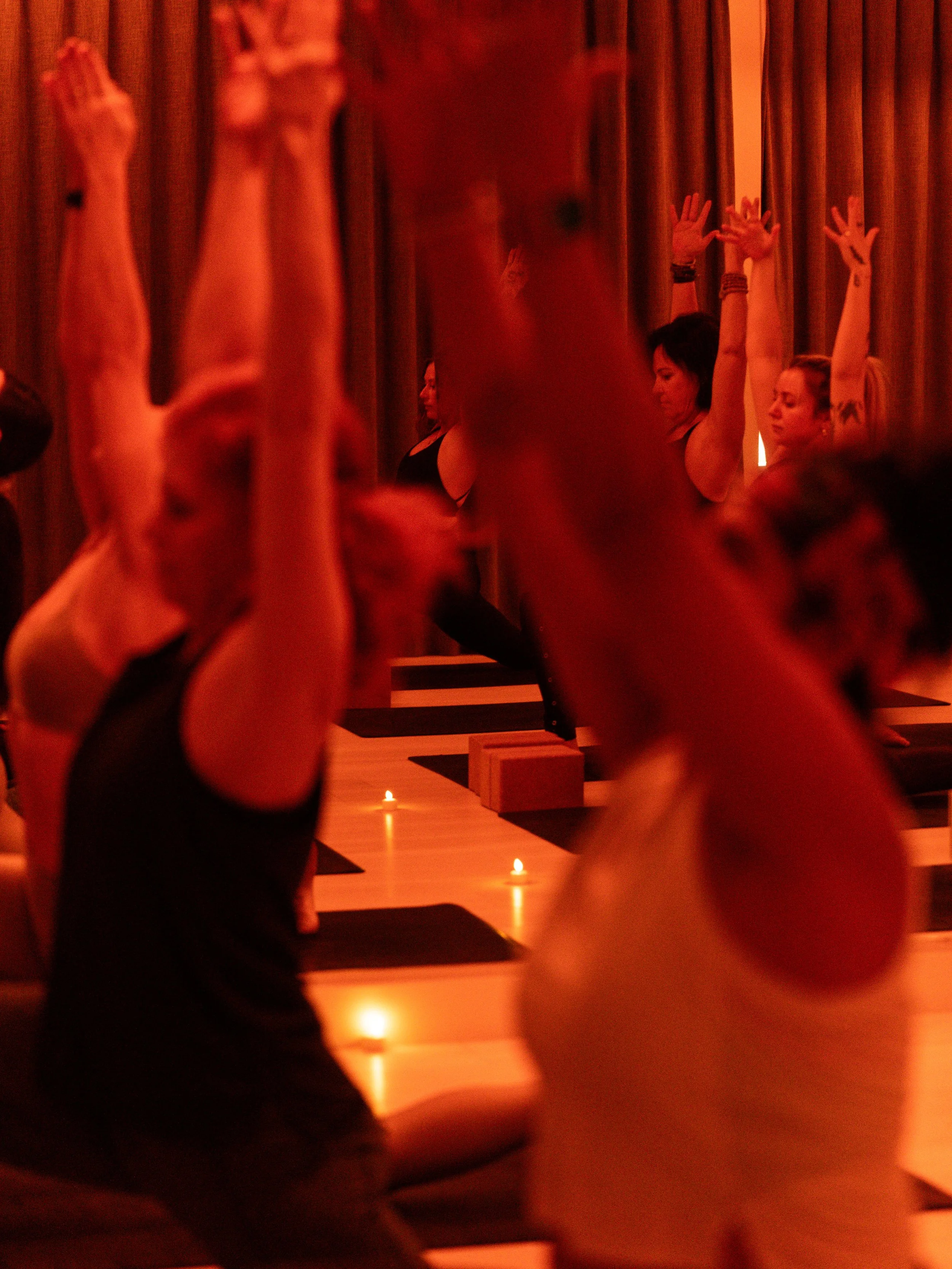 Practitioner flowing through a hot yoga pose in a heated studio, focusing on breath and mindful movement
