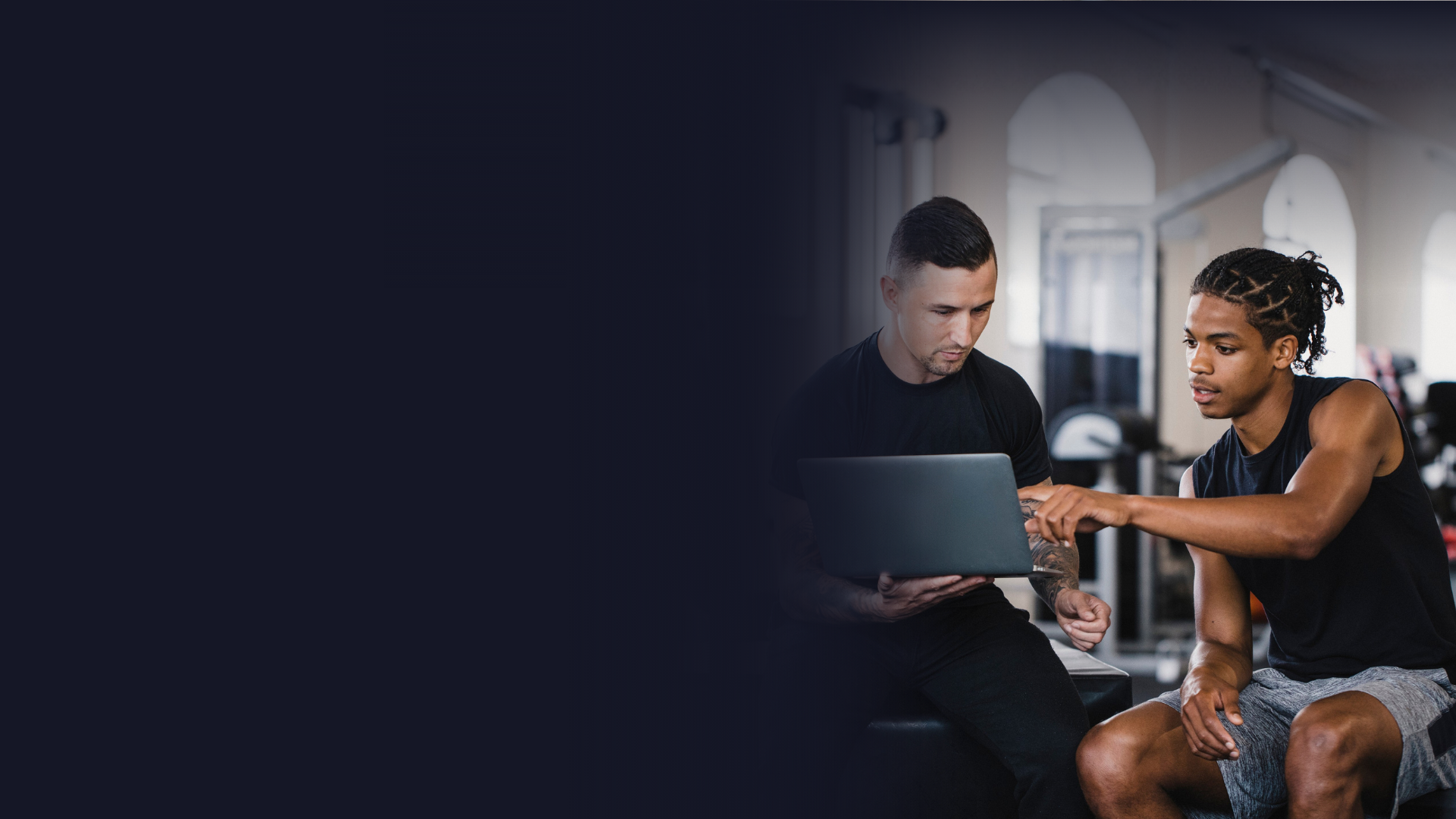 An athlete working with a mental performance coach, looking at a laptop together.