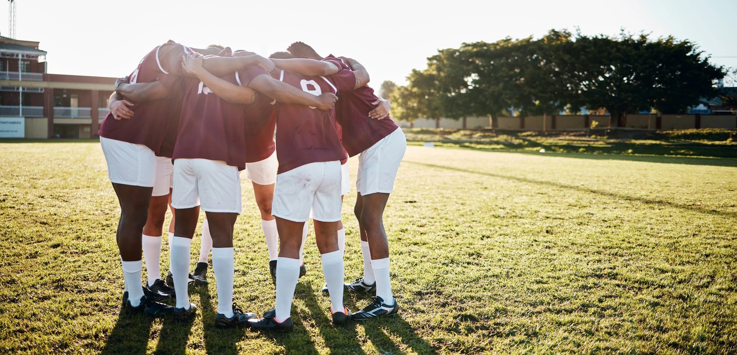 Image of a soccer team in a huddle on the field