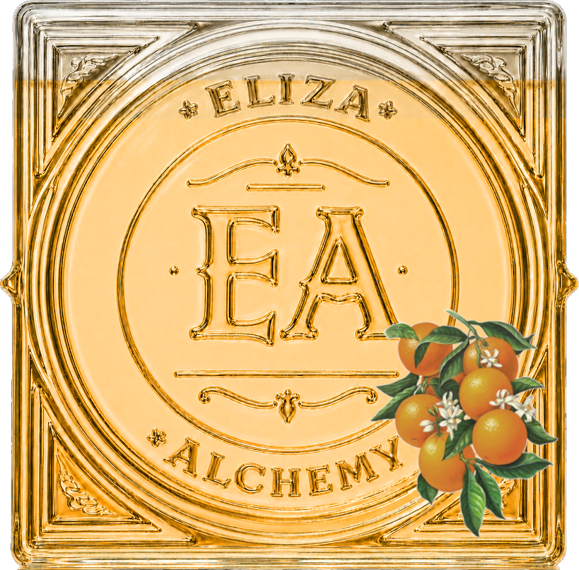 A decorative square embossed glass panel with the words "ELIZA ALCHEMY" and a central emblem containing the letters 'E' and 'A'. There is a small cluster of oranges with green leaves and white flowers in the lower right corner.