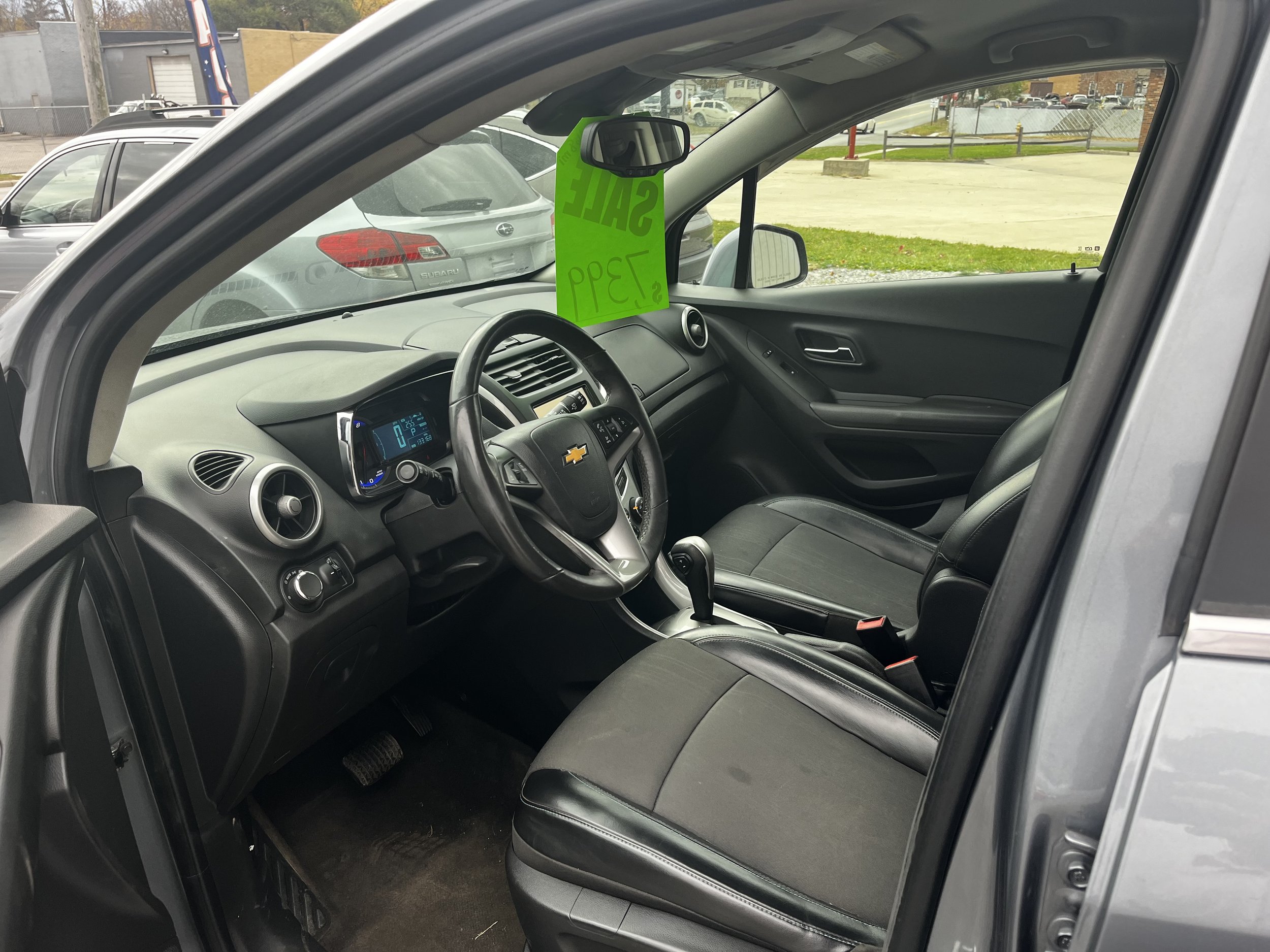 Interior view of a Chevrolet car, showing the steering wheel, dashboard, and front seats.