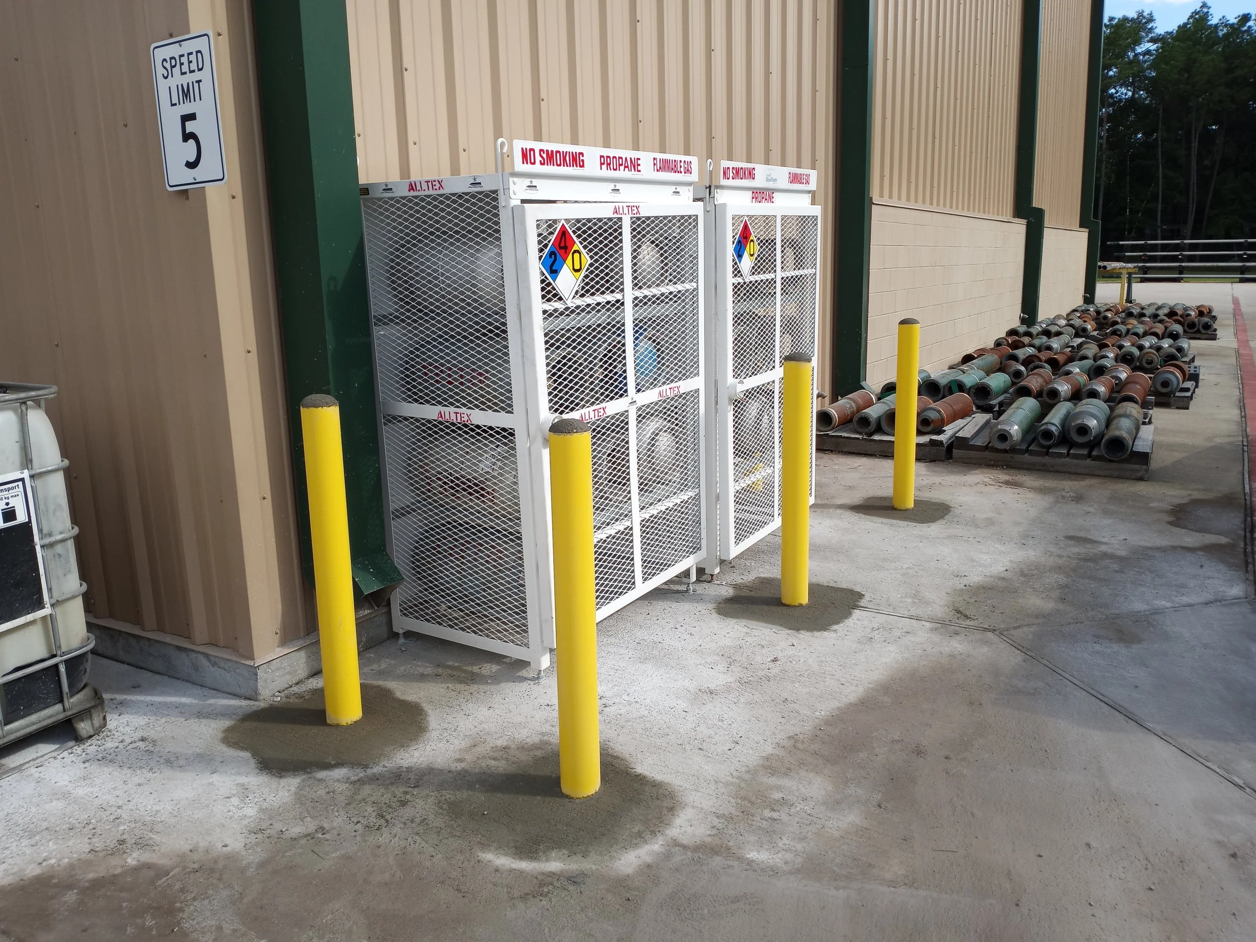 Four inch bollards protecting a propane storage cage