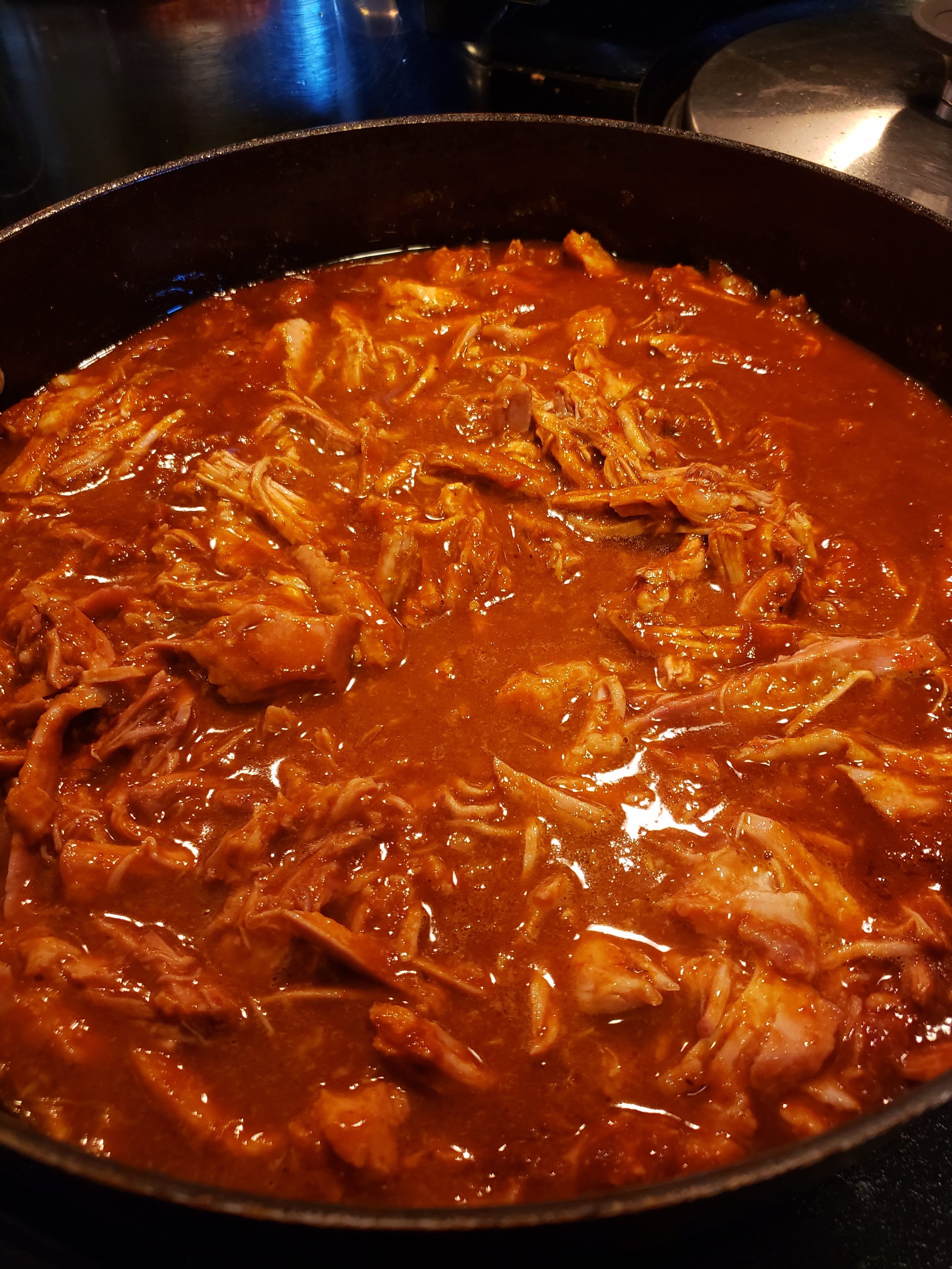 Shredded pork in red sauce in a skillet