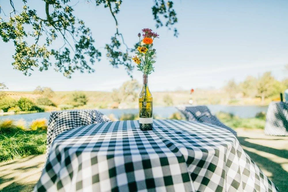 Bottle of wine with flowers on display at table at Grassini Estate.