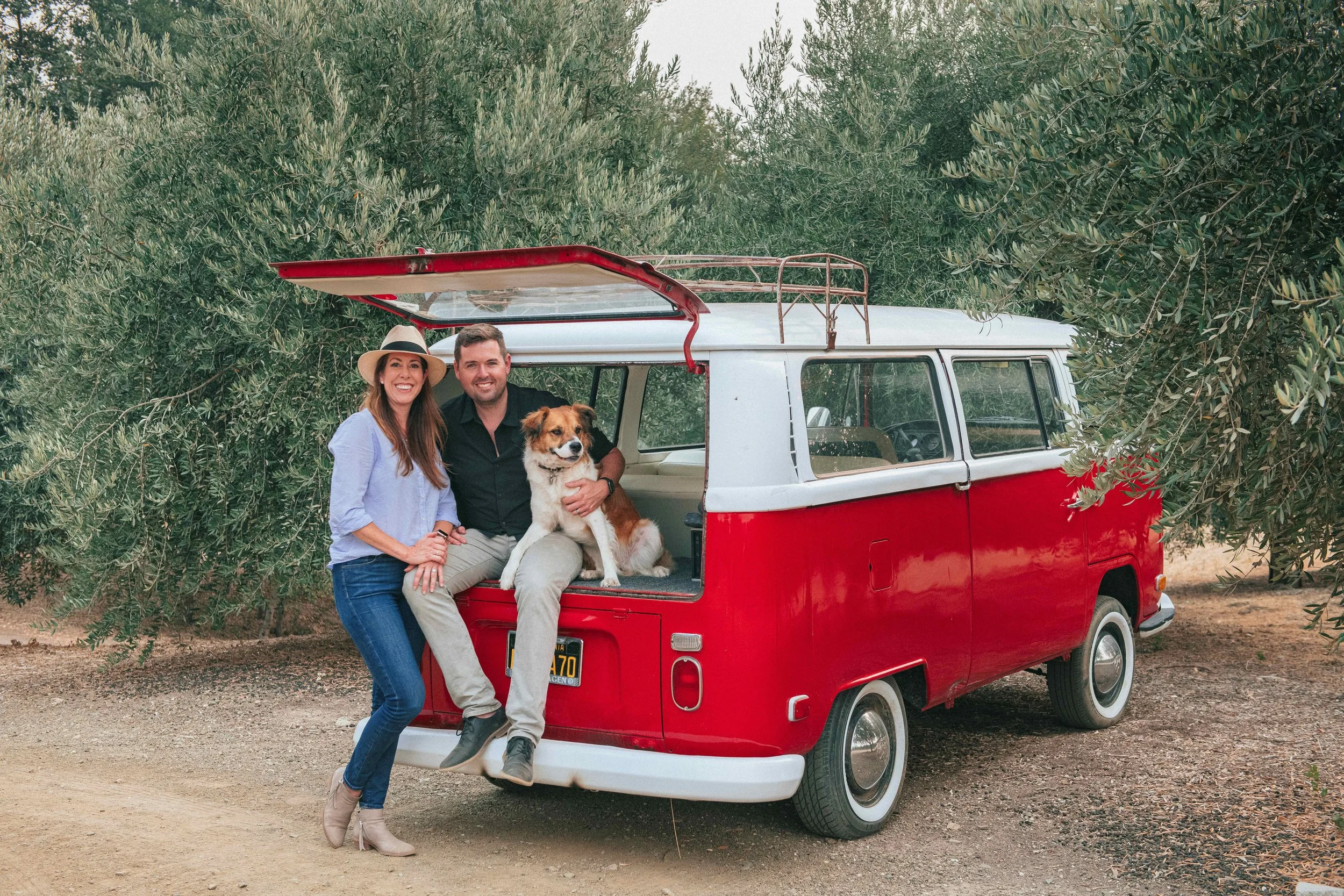 Katie Grassini and Dean McKillen sit in the back of a red VW van with their pet dog, Duffy, at the Grassini Family Vineyards Estate in Santa Ynez.