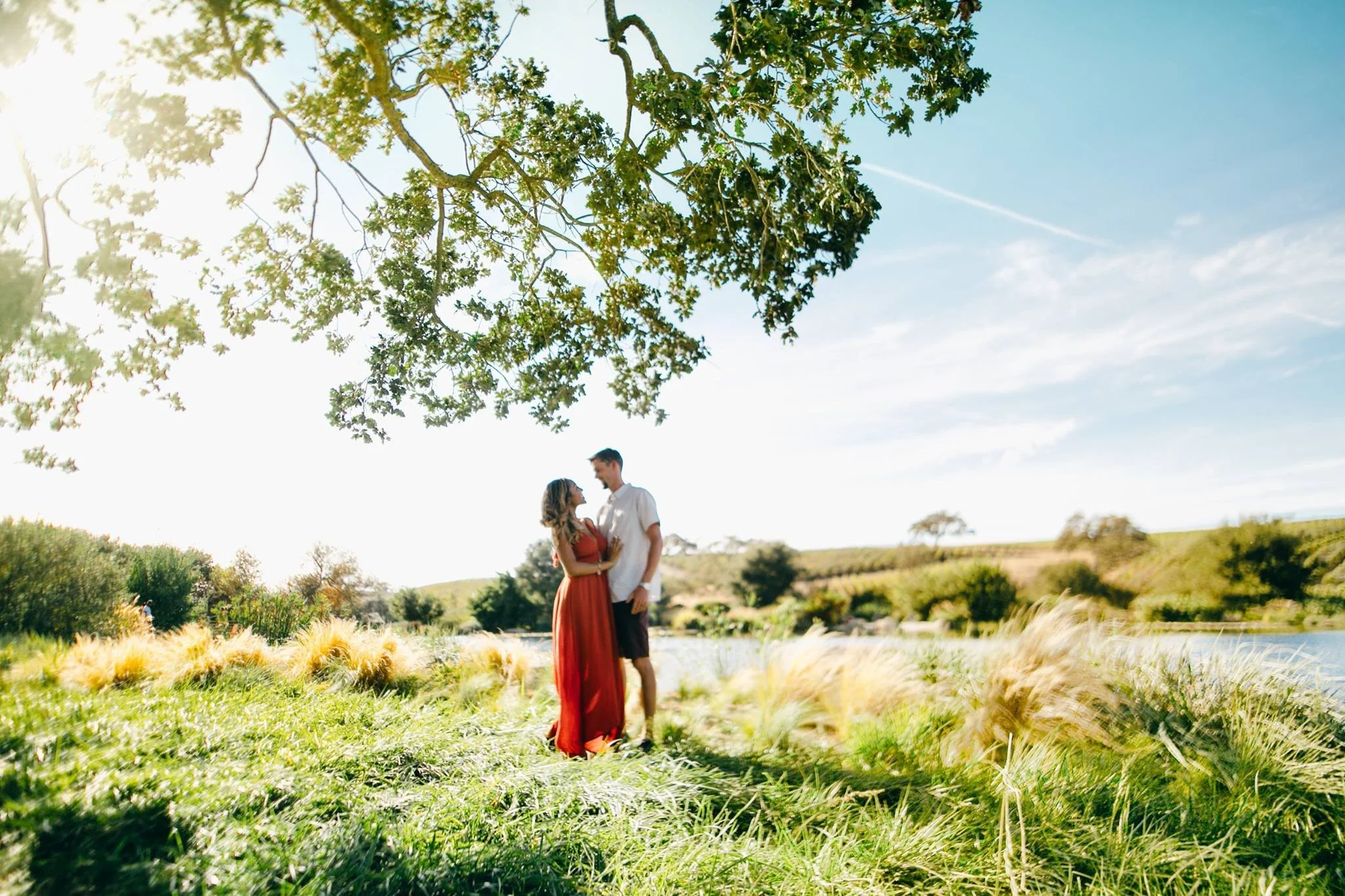 Two event guests posting in front of scenic estate pond.