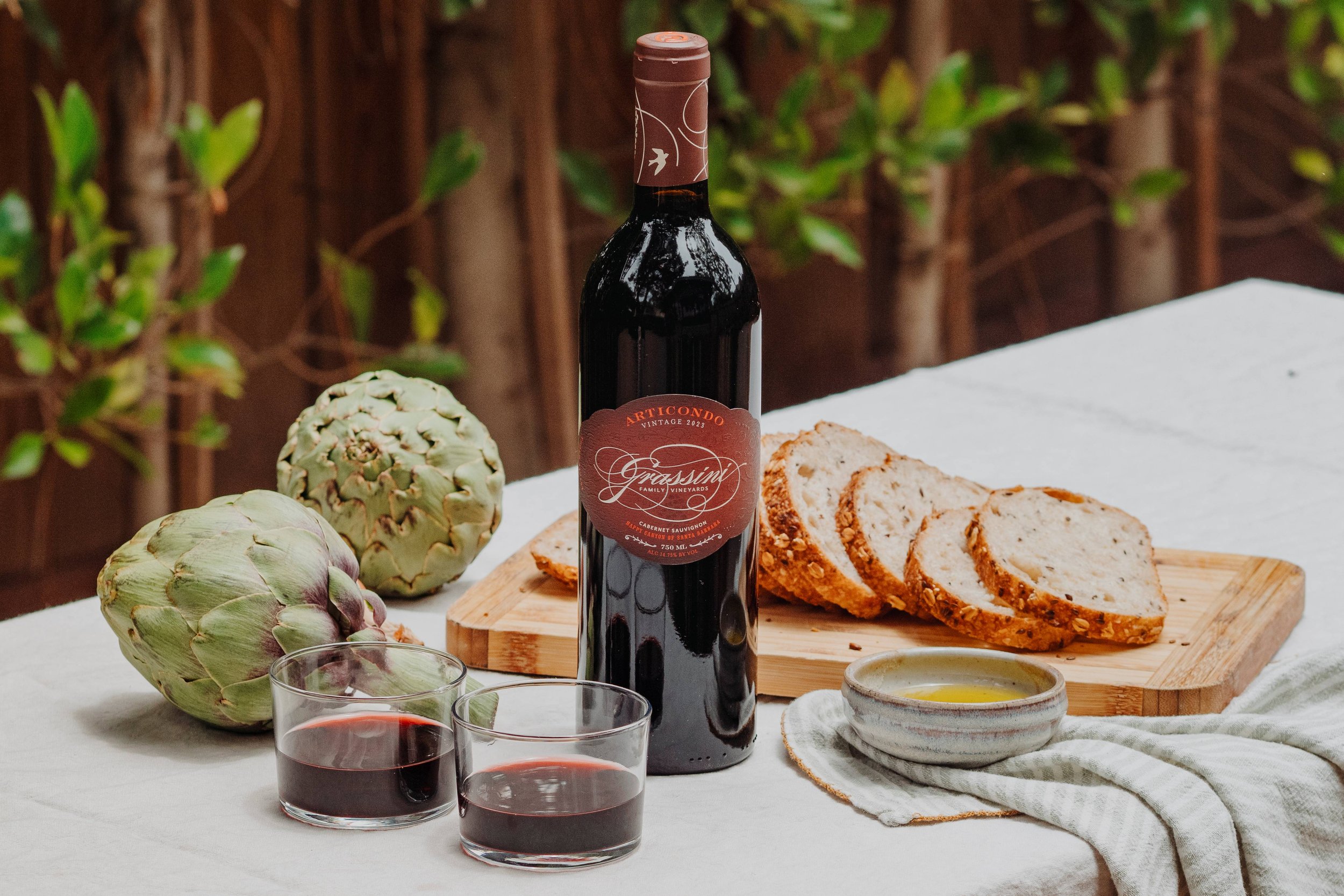 Bottle of our Articondo Proprietary Red on a table with charcuterie.