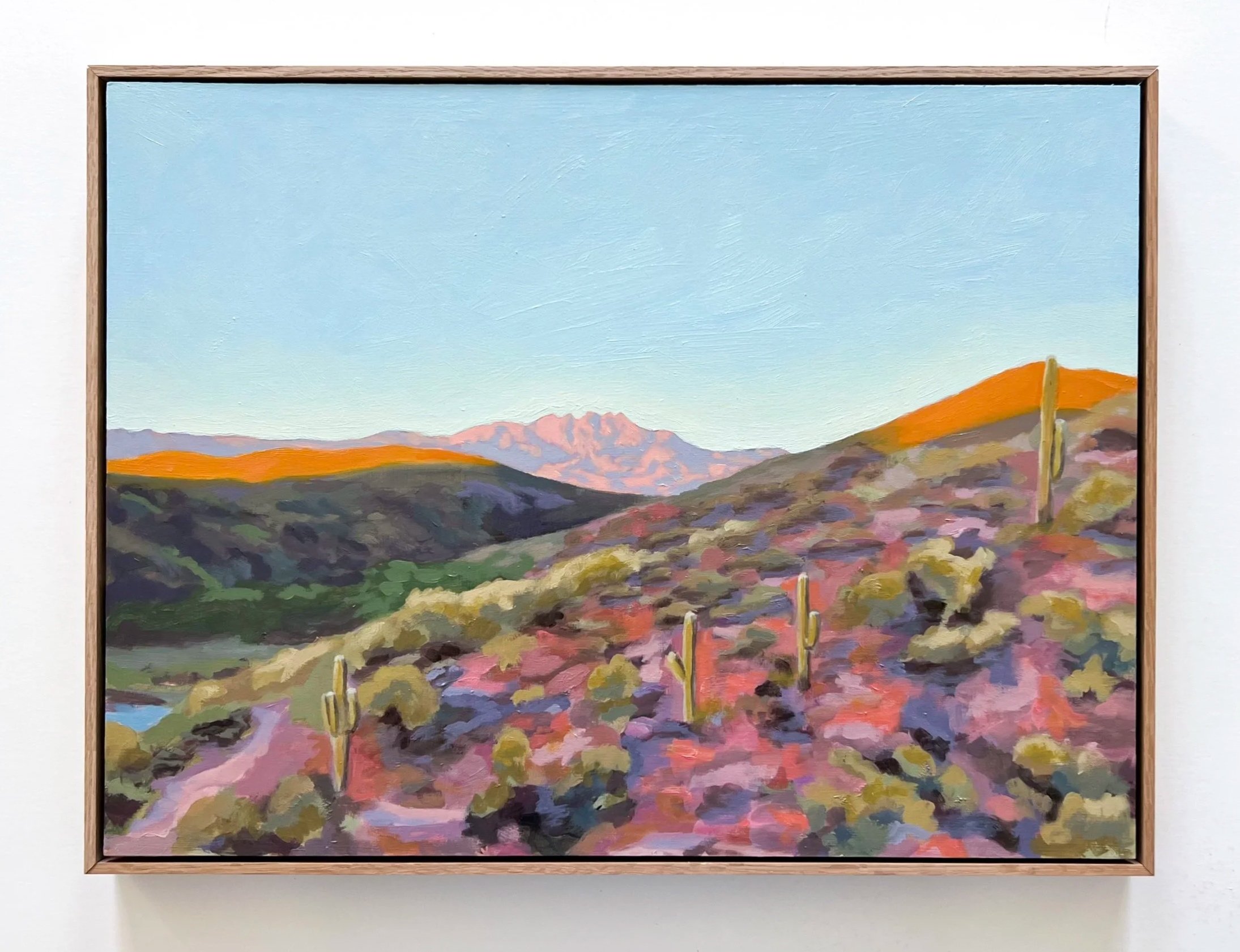 Framed painting of a desert landscape with pink and blue mountains