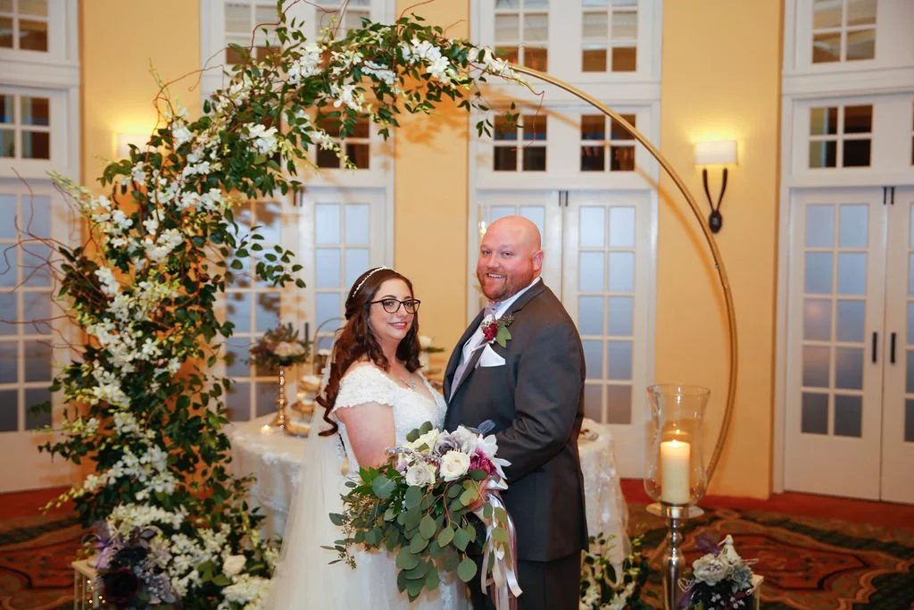 Bride and groom with floral display by Kathy Reynolds Wedding Florist.jpg