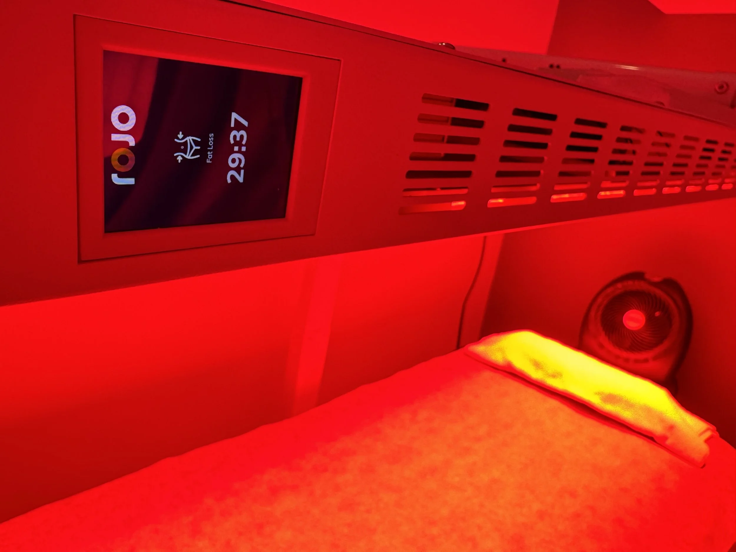 Red light therapy device with timer showing 29:37 in a treatment room