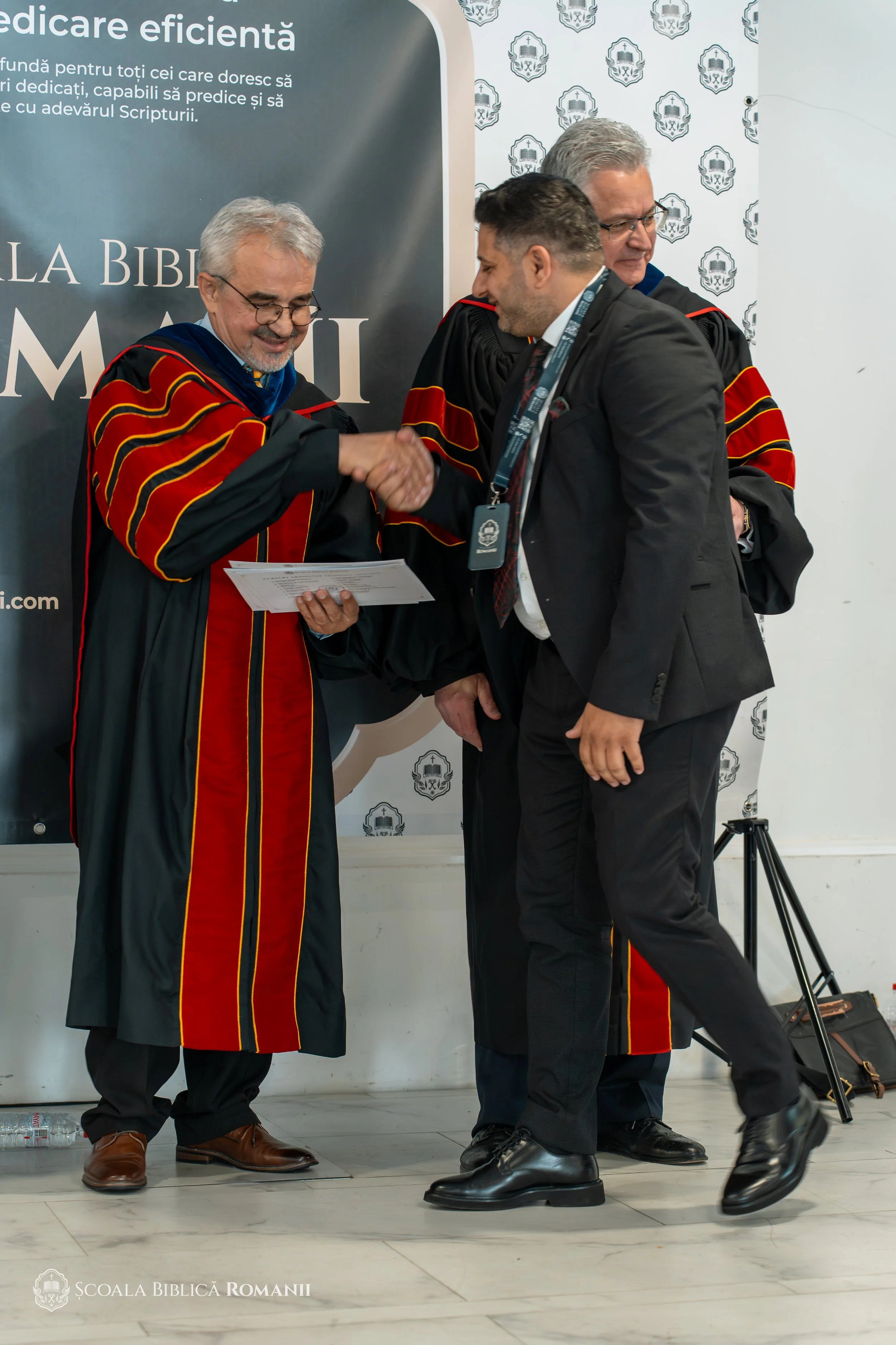 Profesori și absolvent la ceremonia din Hagen.