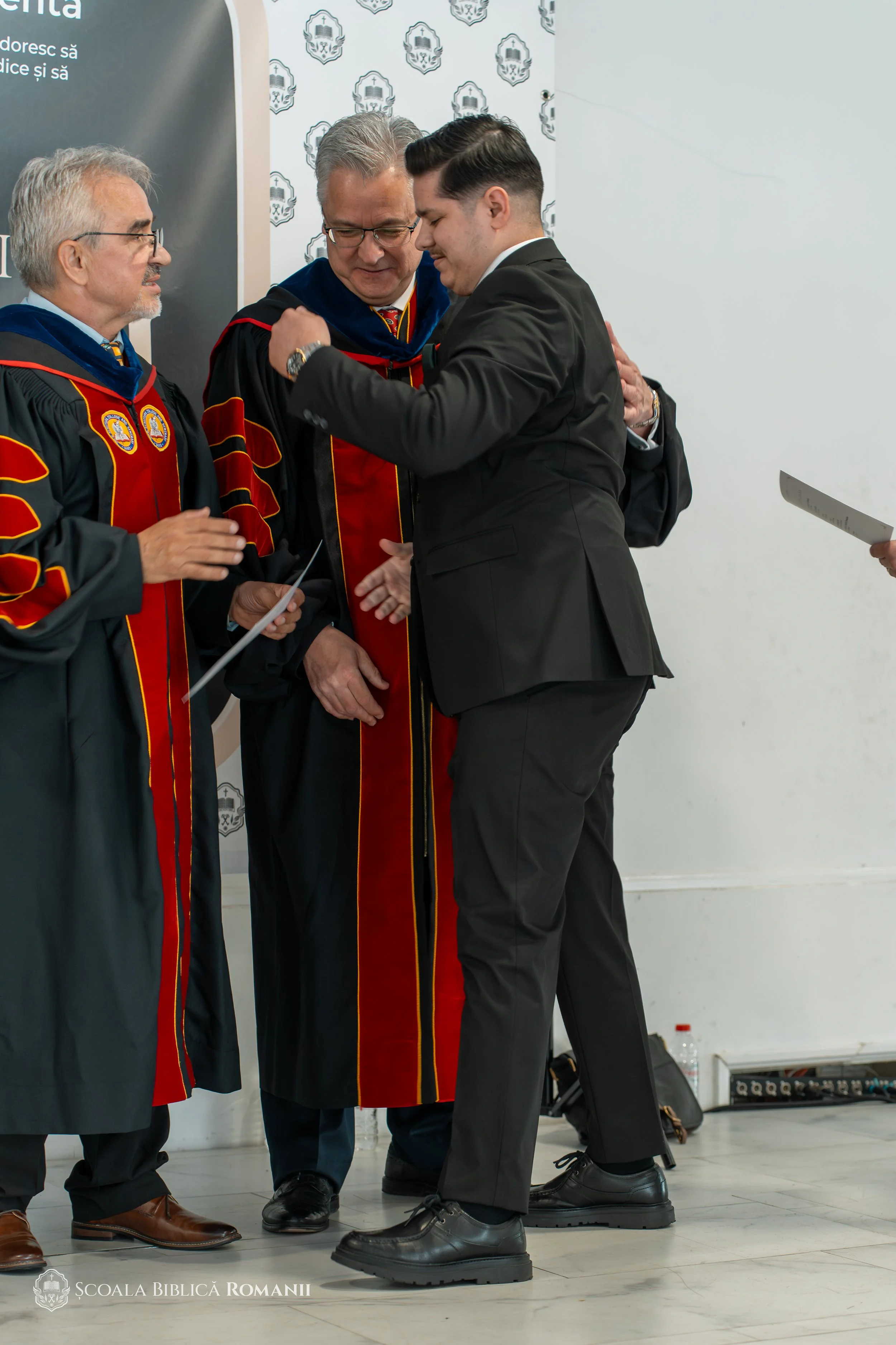 Moment de bucurie și îmbrățișare la ceremonia de absolvire.