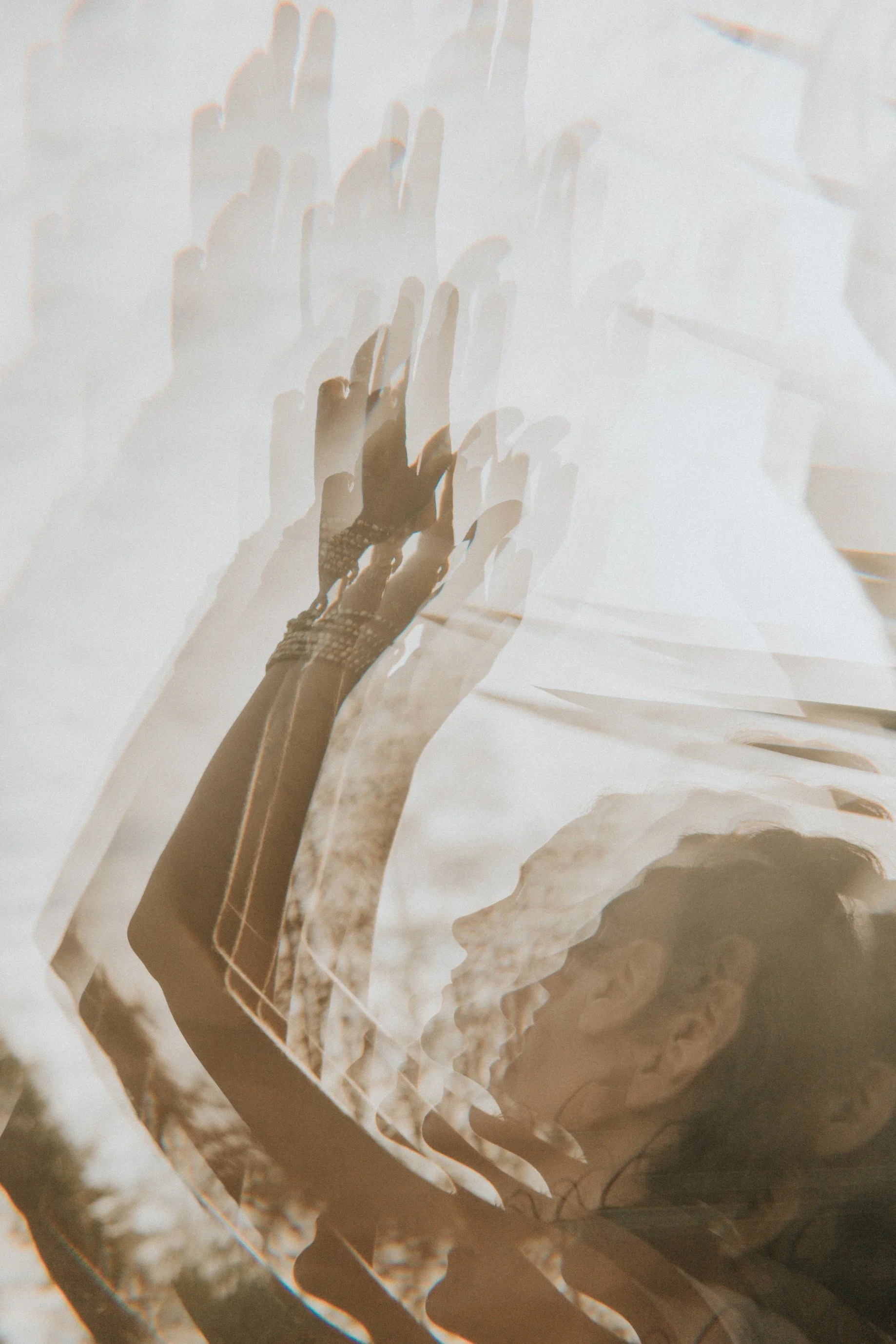 Varias manos y una mujer en perfil con gafas, en un efecto de doble exposición con tonos sepia.