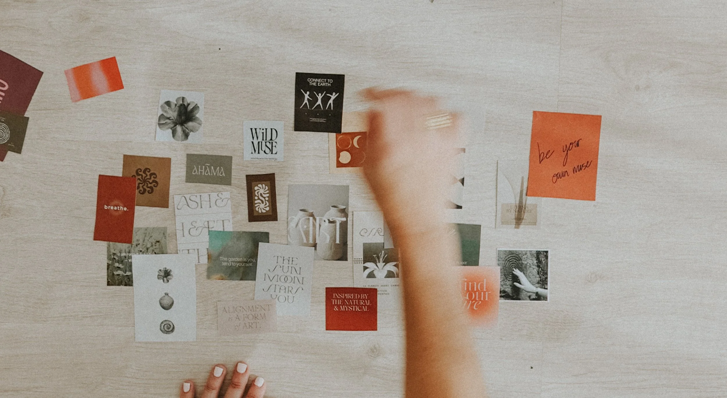 Mano colocando notas adhesivas en una mesa de madera. Las notas contienen textos motivacionales y diseños en diferentes colores y estilos.