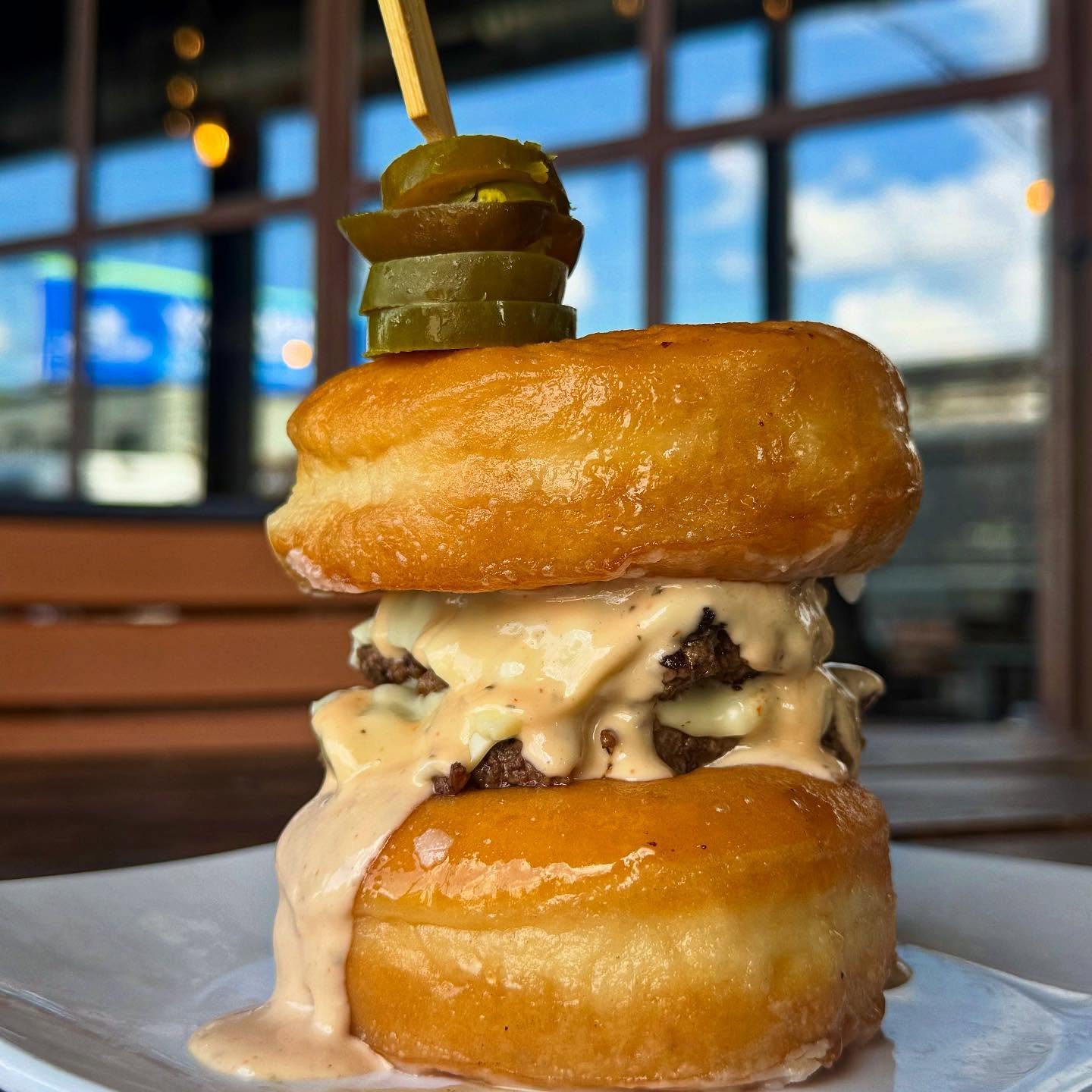 🚨 Warning!: this burger doesn’t play by the rules. 🍩🔥
Double smash patties, melty cheese, spicy jalapeños, and glazed donuts for buns. Sweet, savory, messy, and 100% worth it.
Only at Bear and the Butcher.