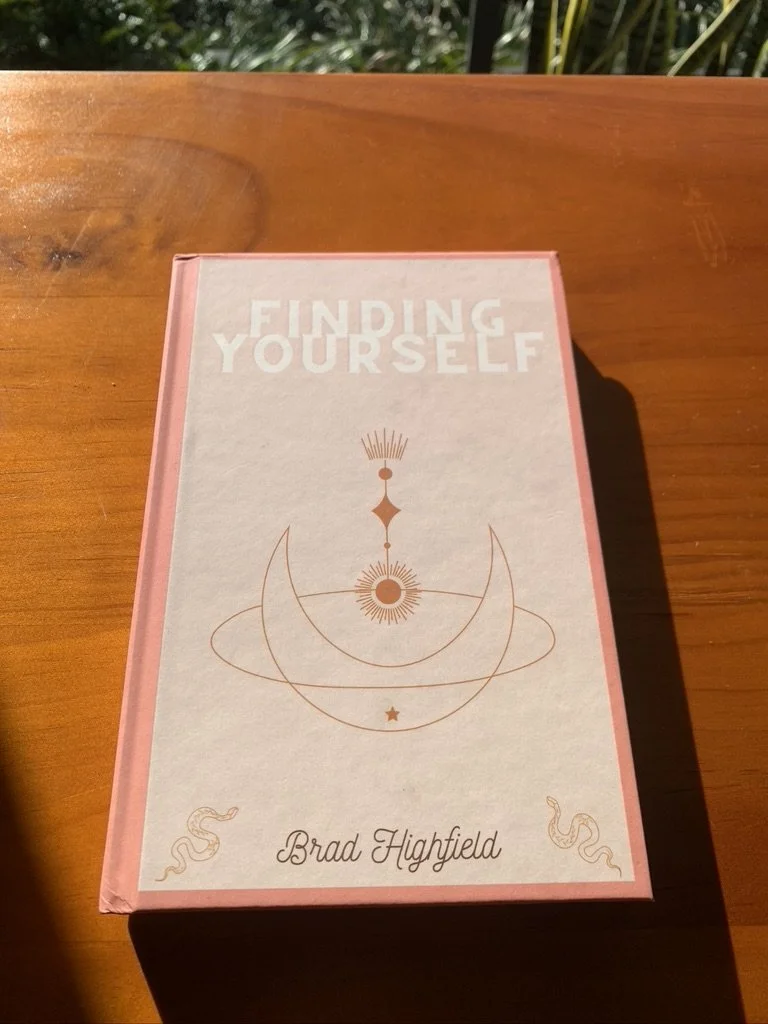 Book titled 'Finding Yourself' by Brad Highfield resting on a wooden table.