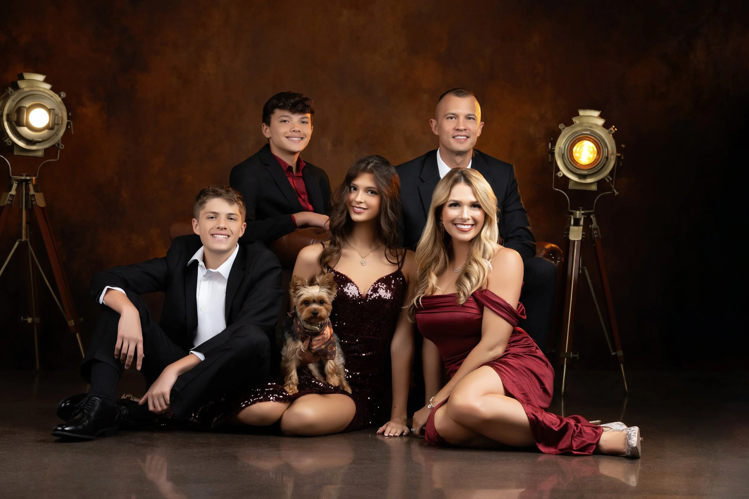 A formal family poses with their dog at Megan Michael Photography Studio in Gretna