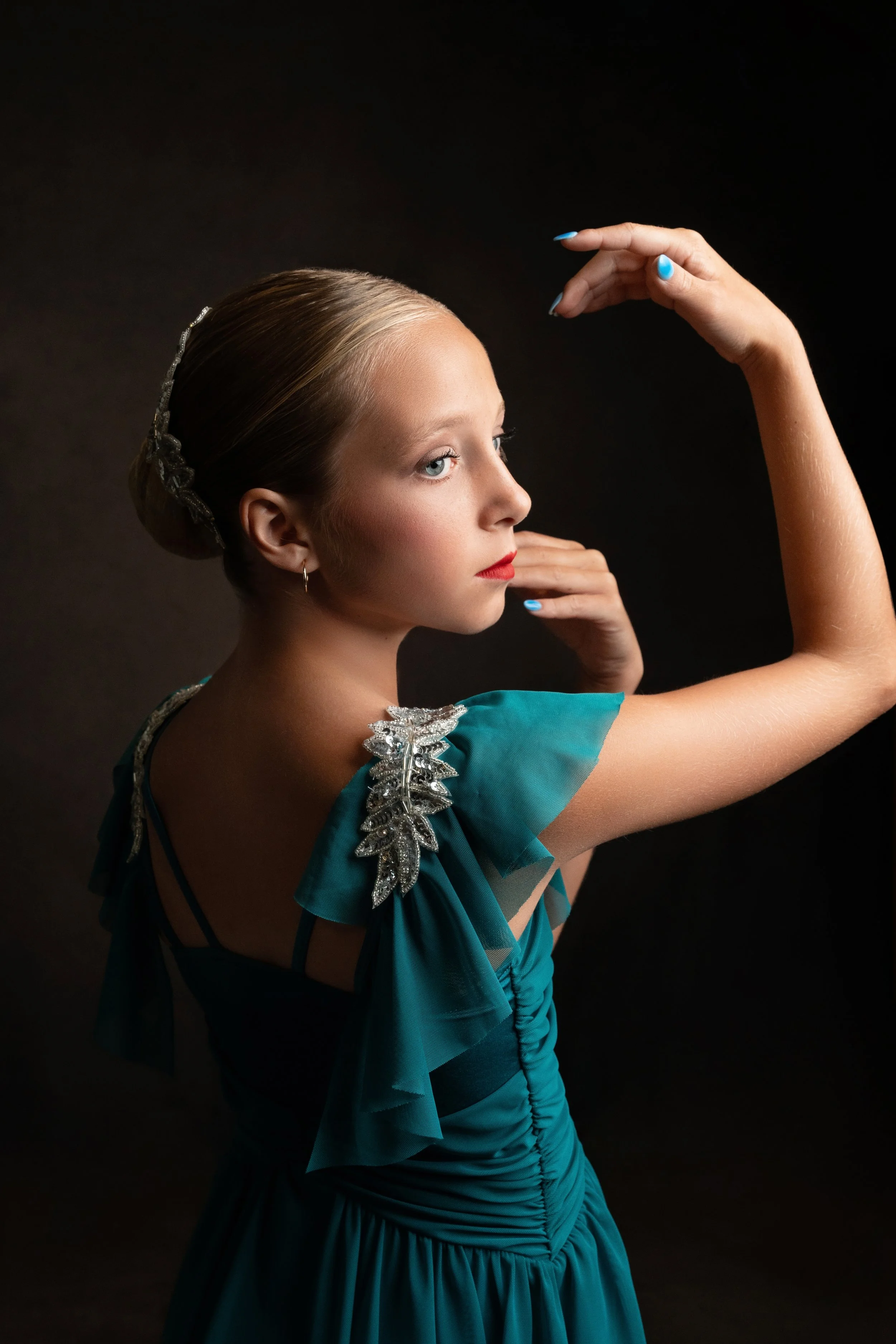 A ballerina in a teal costume poses at Megan Michael Photography during her dance session