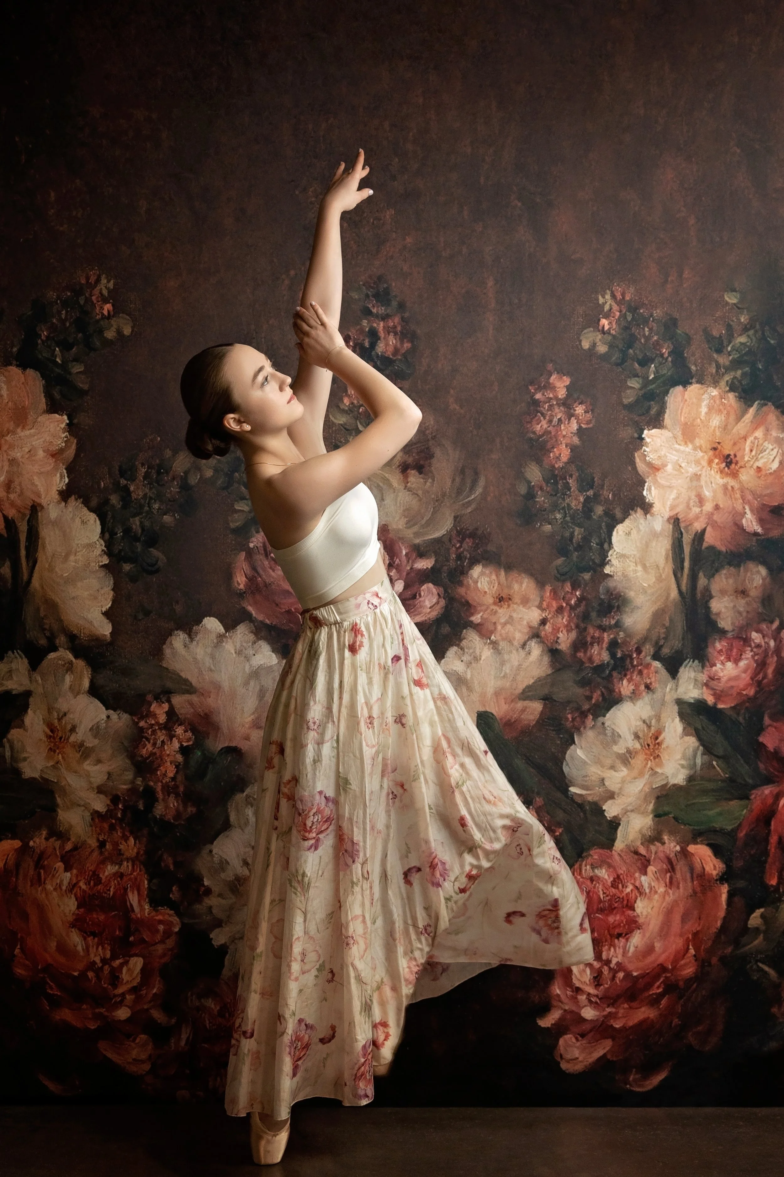a point dancer in a floral skirt dances in front of a floral wall in Gretna, Nebraska