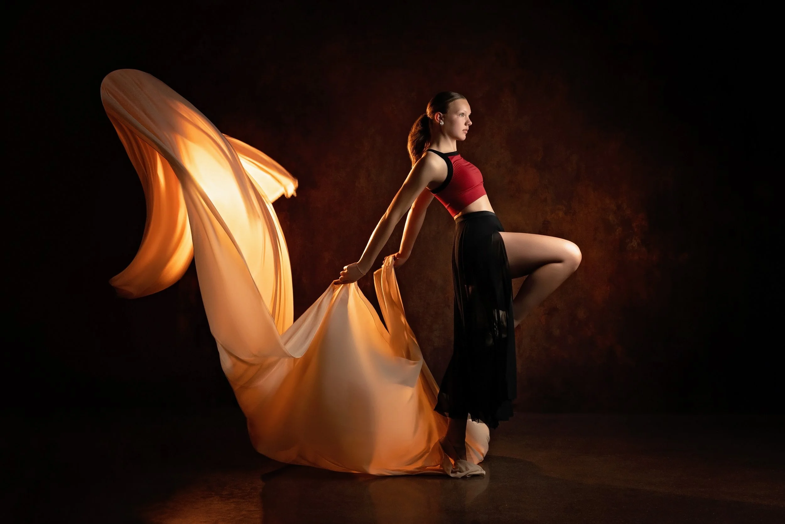 A dancer uses fabric to dance and bring movement to her phot session