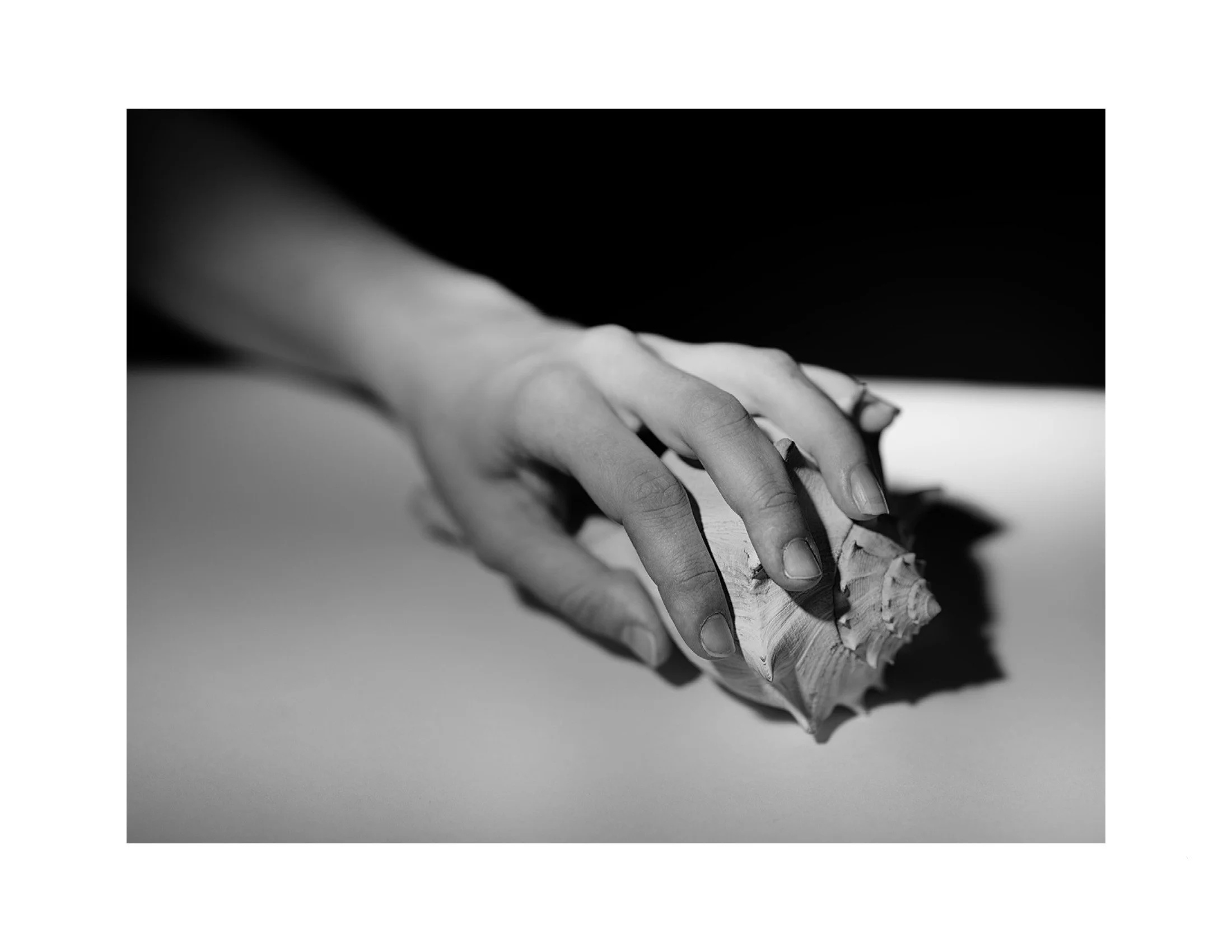 Black and white photo of a hand holding a broken pencil.
