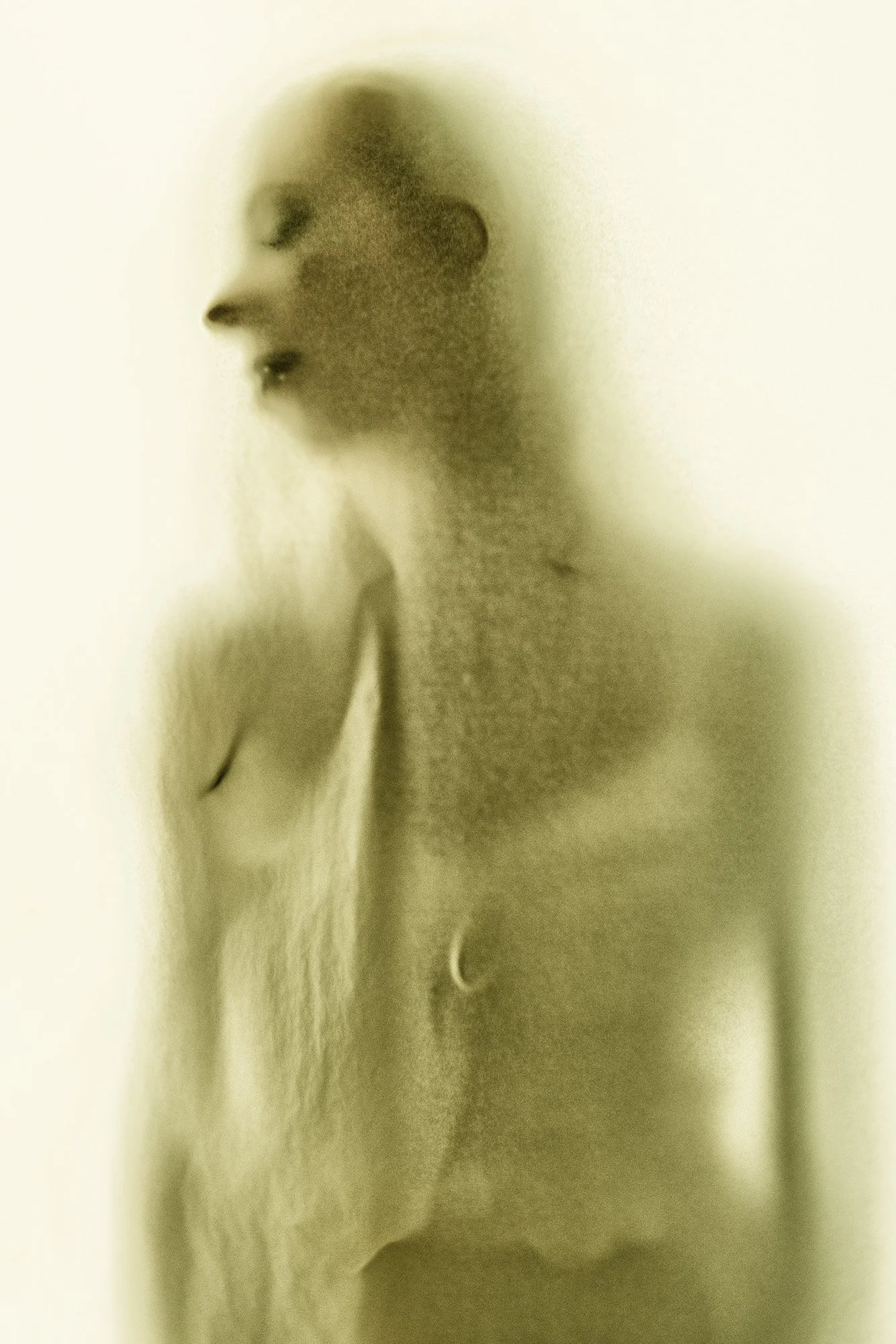 A side profile of a person with a blurred, semi-transparent appearance, featuring closed eyes and a gentle expression.