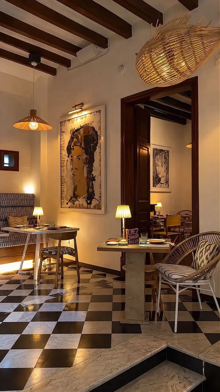 A salon at Chez Junior Sóller, with a beamed ceiling and a black and white tiled floor
