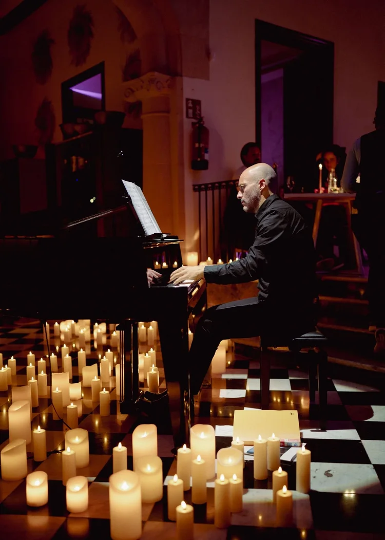 A pianist playing by candlelight in the main salon of Chez Junior Sóller