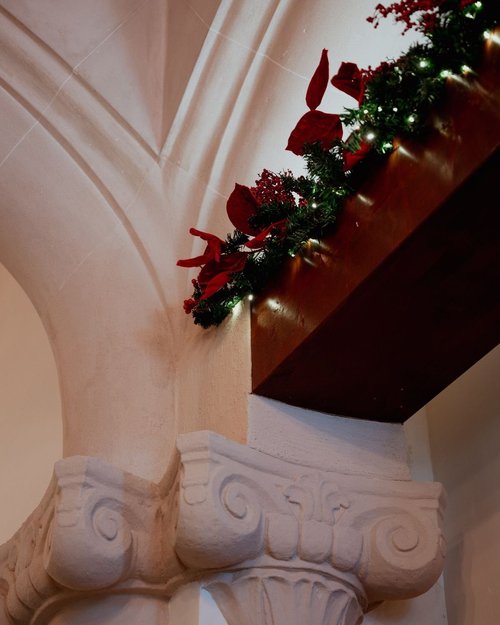 A stone column in the palacete, wrapped in a Christmas garland