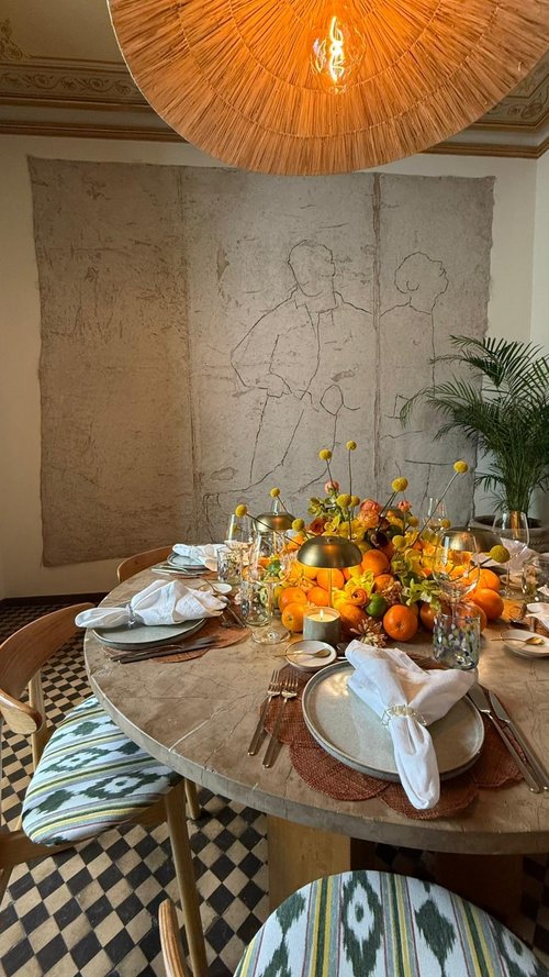 A round table dressed with flowers and oranges