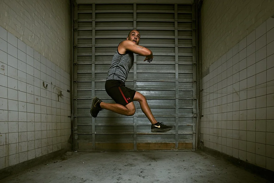 Active lifestyle photography by Justin Munitz. A model in athletic clothing jumping in an industrial space.