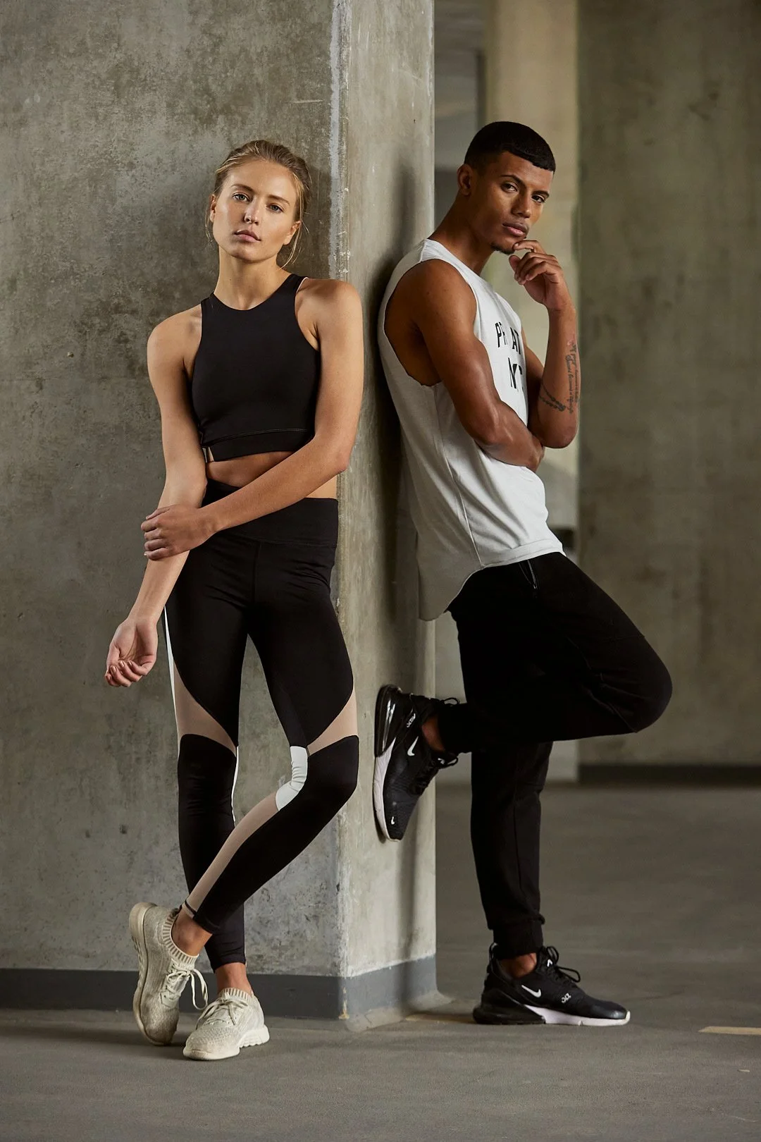 Active lifestyle photography by Justin Munitz - two models in athletic clothing leaning against a concrete wall