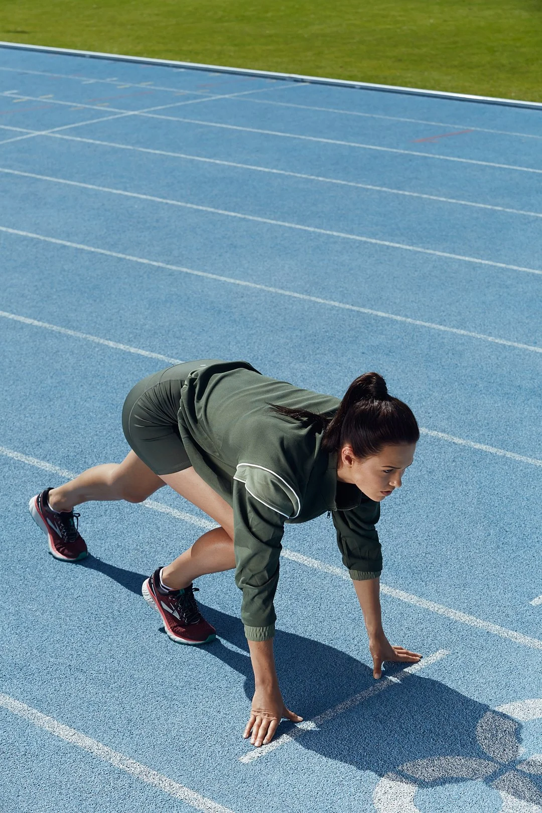 Active lifestyle photography by Justin Munitz  - model in starting position on a running track.
