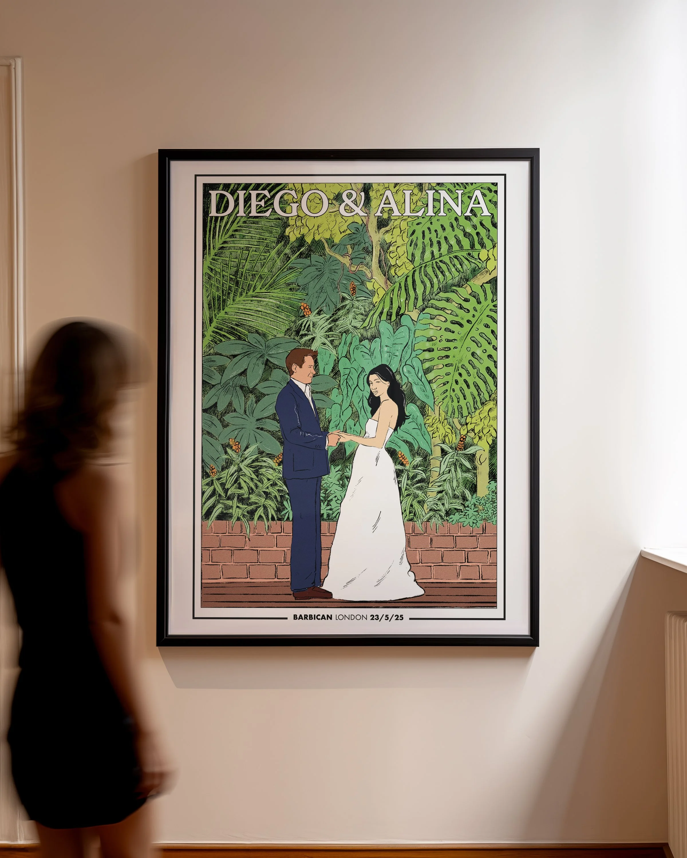 Framed artwork showing a couple holding hands in front of lush green tropical plants, with the text 'DIEGO & ALINA' at the top and details about a wedding at 'BARBICAN LONDON' on 23/5/25 at the bottom.