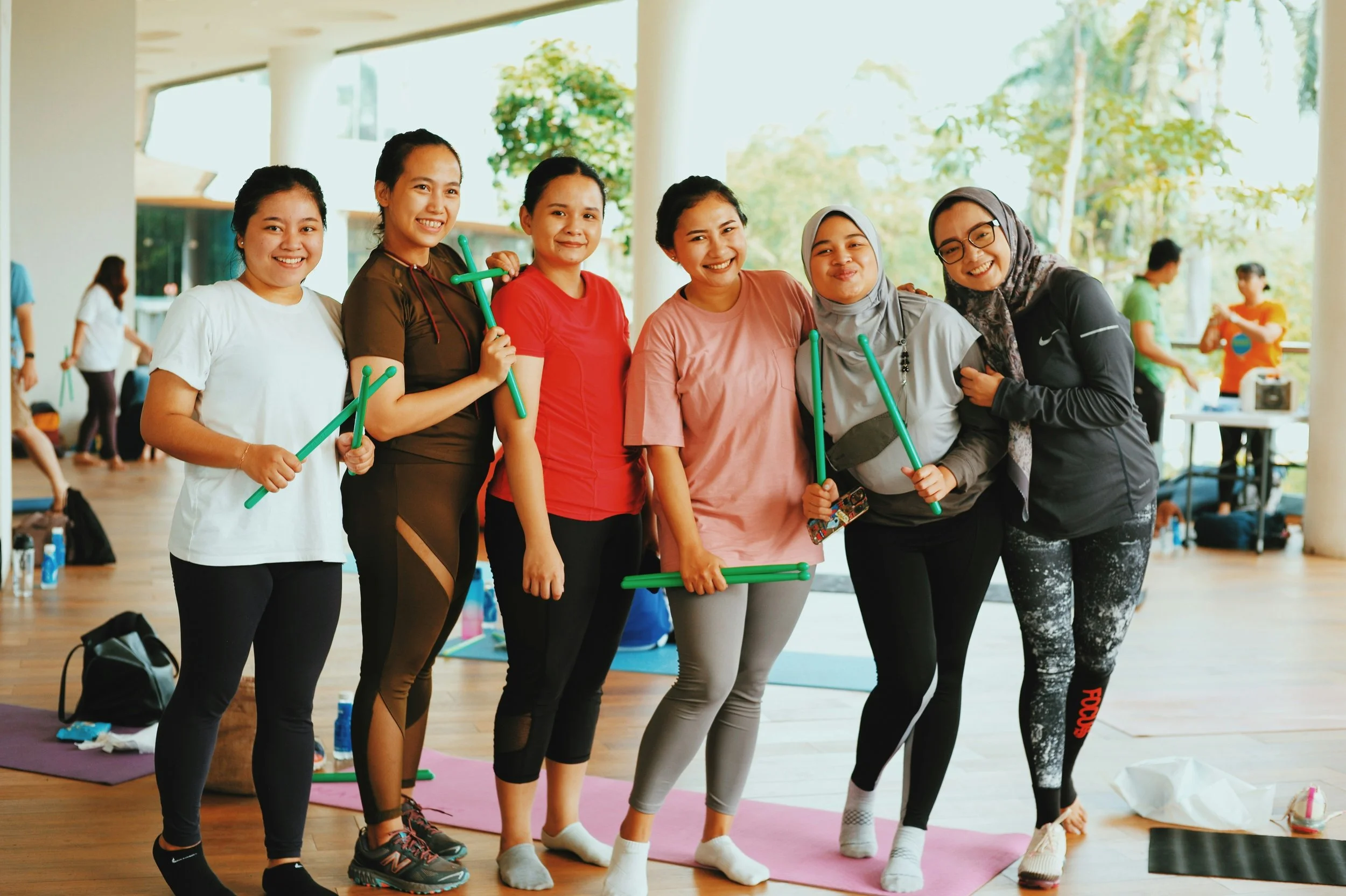 group of six women in their 30a smiling at the camera in a gym