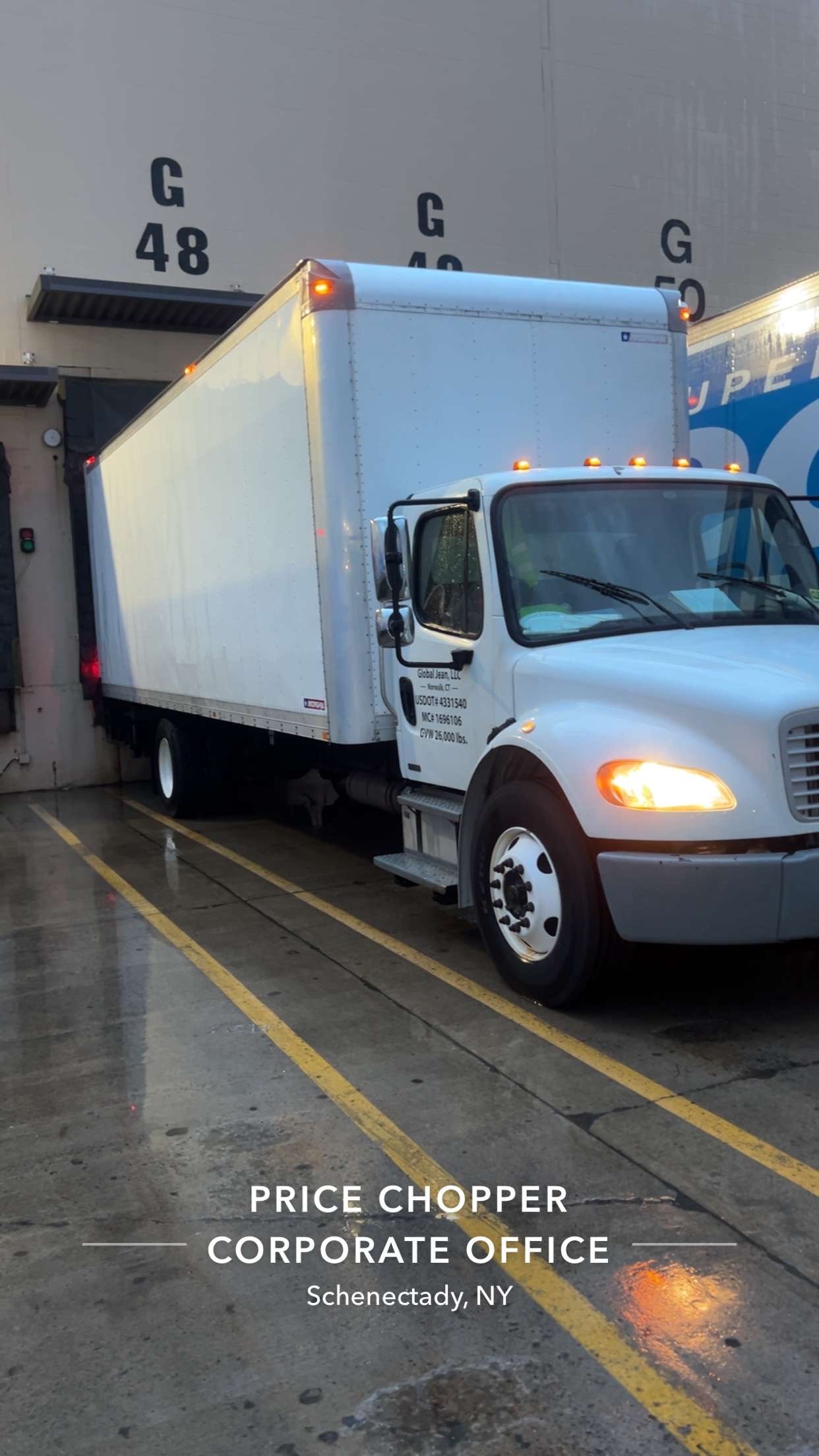 White delivery truck parked in loading dock at Price Chopper corporate office in Schenectady, NY, during rainy weather