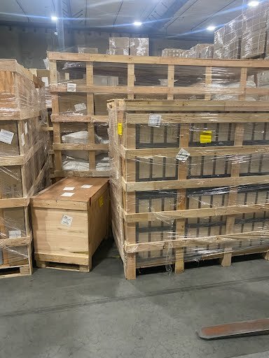 Stacked wooden pallets and crates in a warehouse.