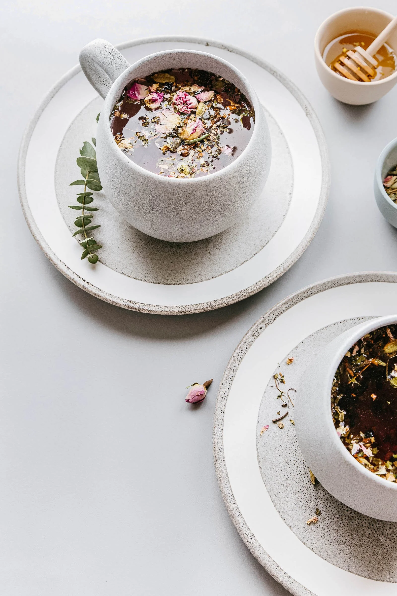 ceramic mugs with tea on plates