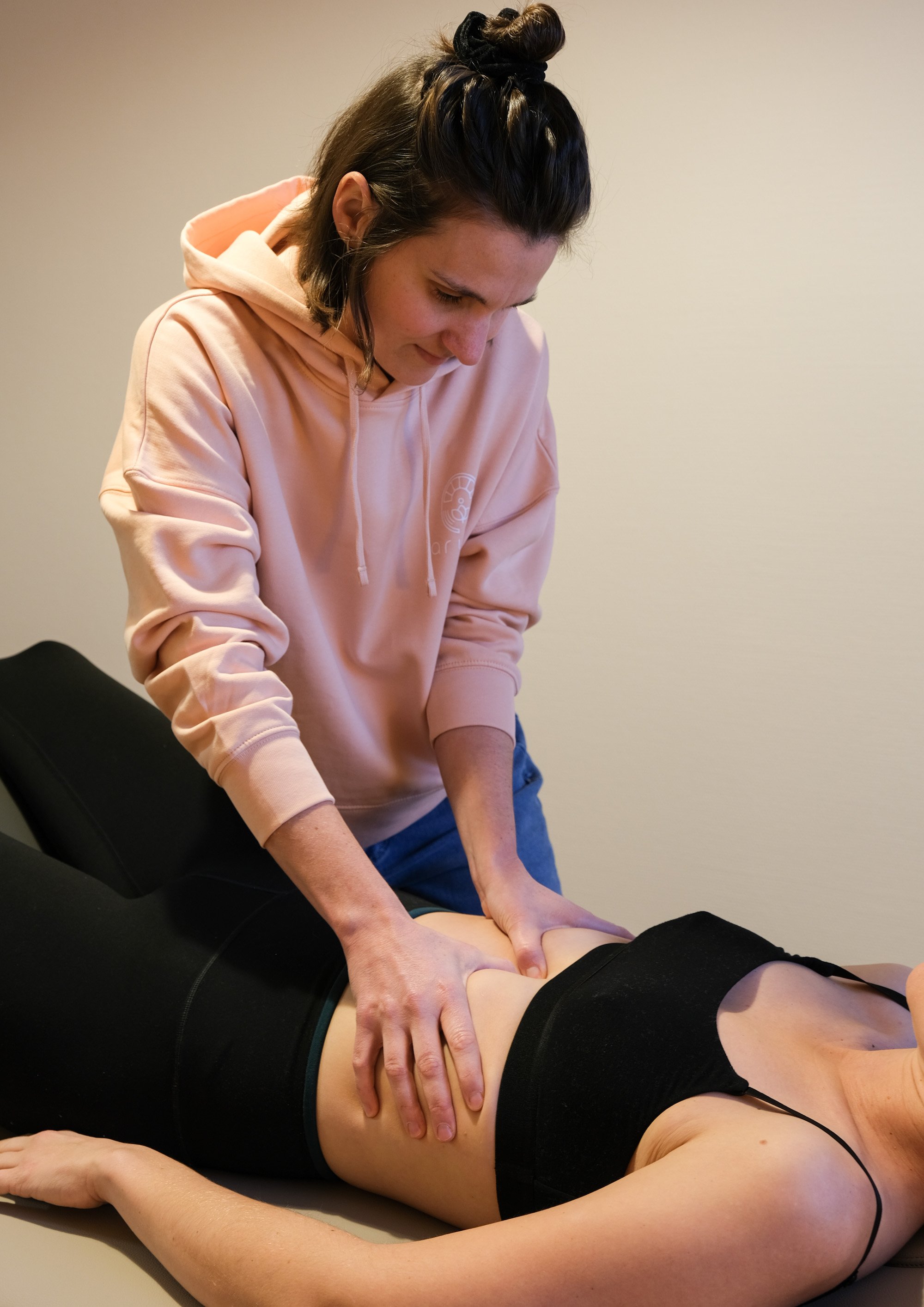 Eine Therapeutin behandelt eine Patientin osteopathisch am Bauch im Gesundheitsatelier Aruna in Remerschen